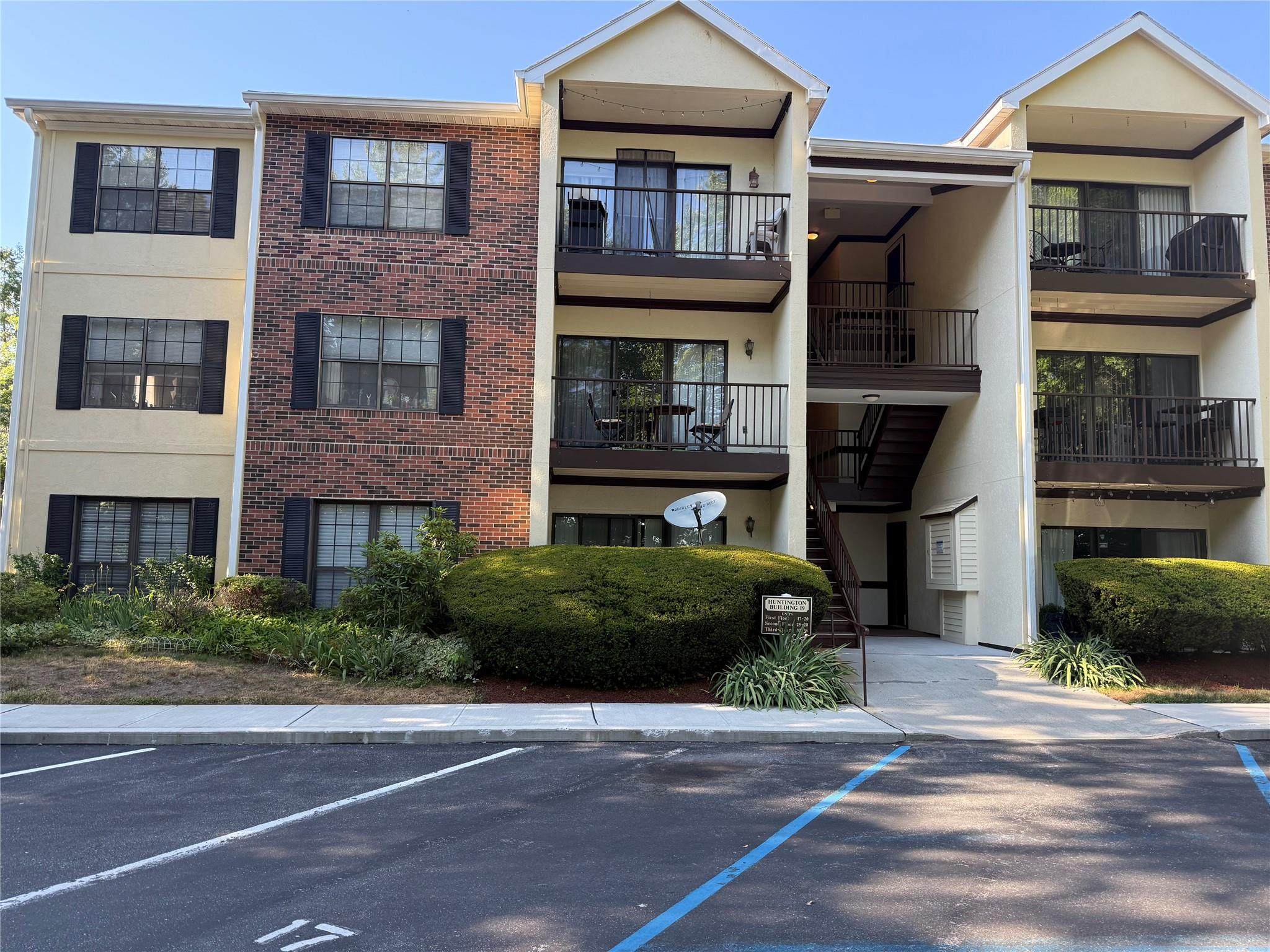 View of apartment building / complex with uncovered parking