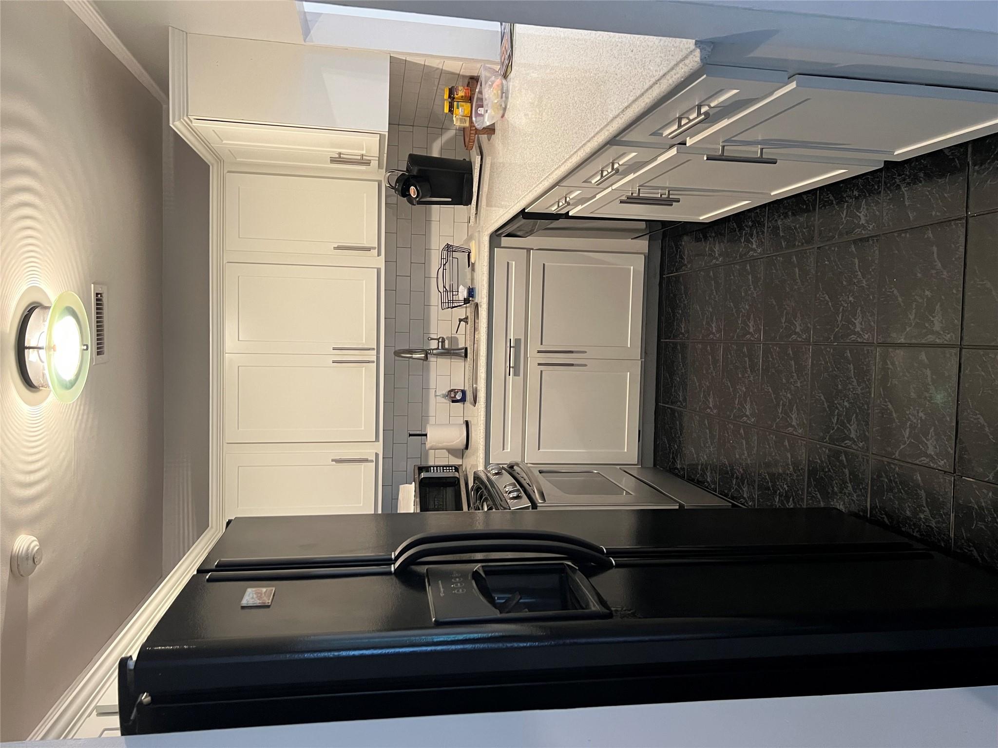 Kitchen with refrigerator, range, decorative backsplash, light countertops, and dishwasher