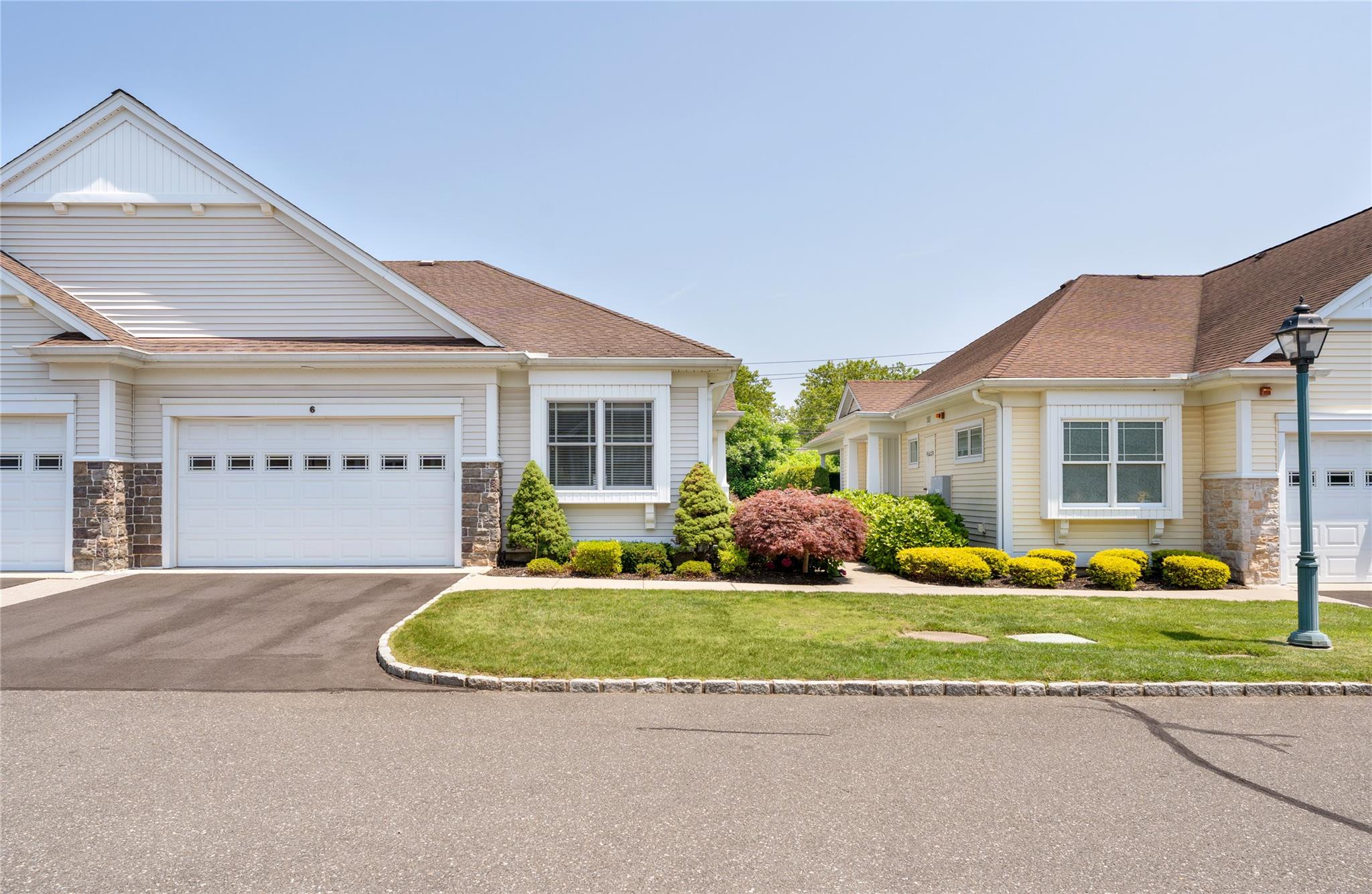 Craftsman-style home featuring driveway, a front yard, a garage, and stone siding