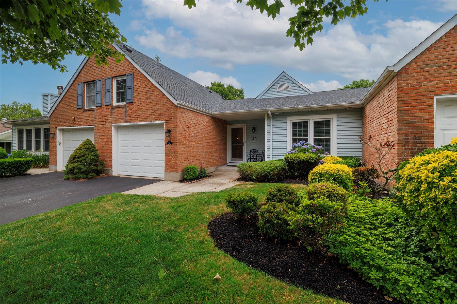 View of front of house featuring driveway, front lawn, and attached garage.