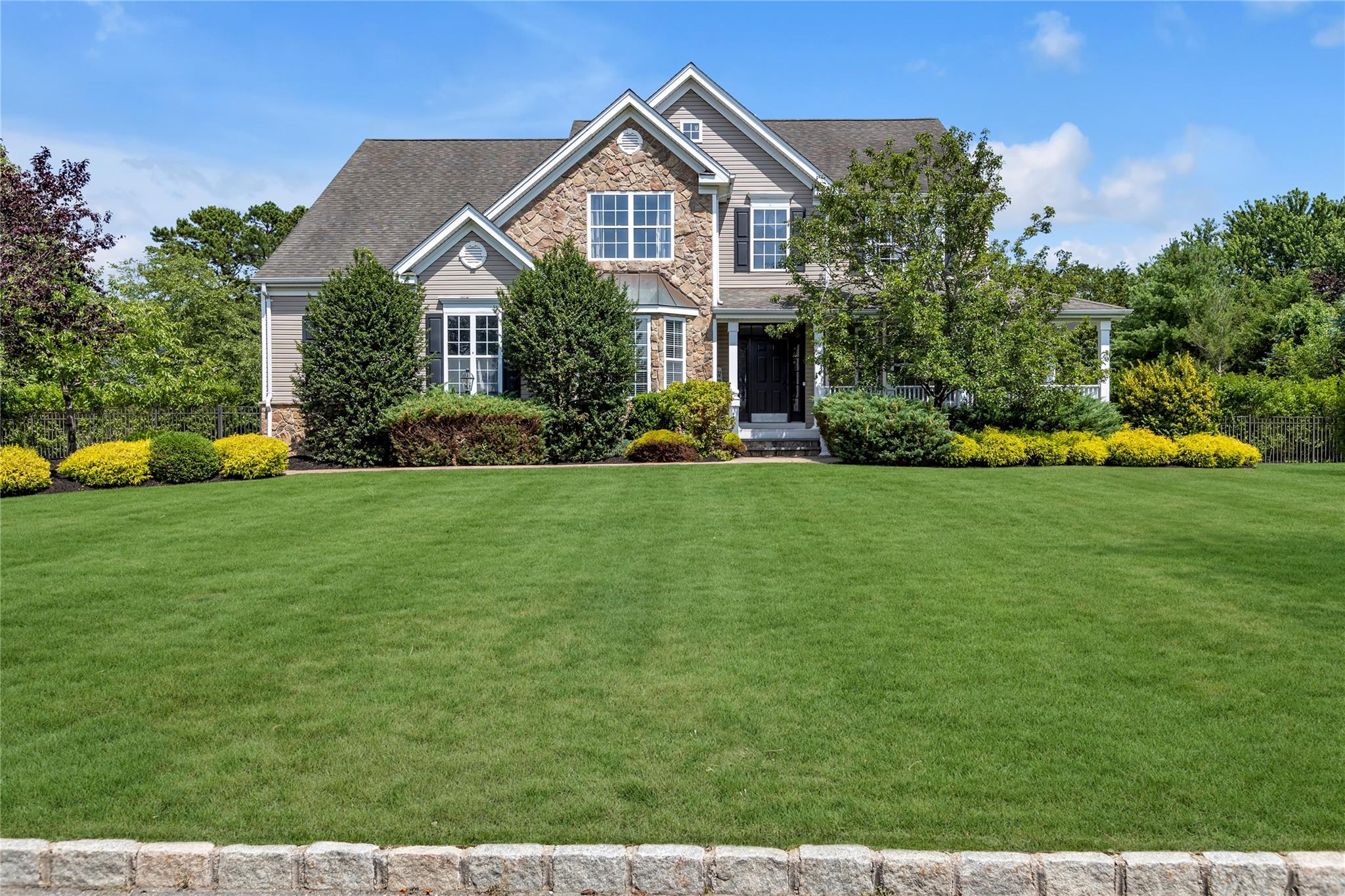 View of front of home with stone siding and roof with shingles