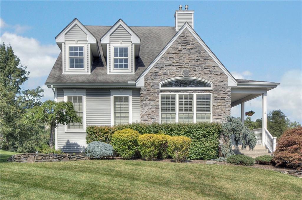 View of front of property featuring a front lawn, a chimney, and roof with shingles