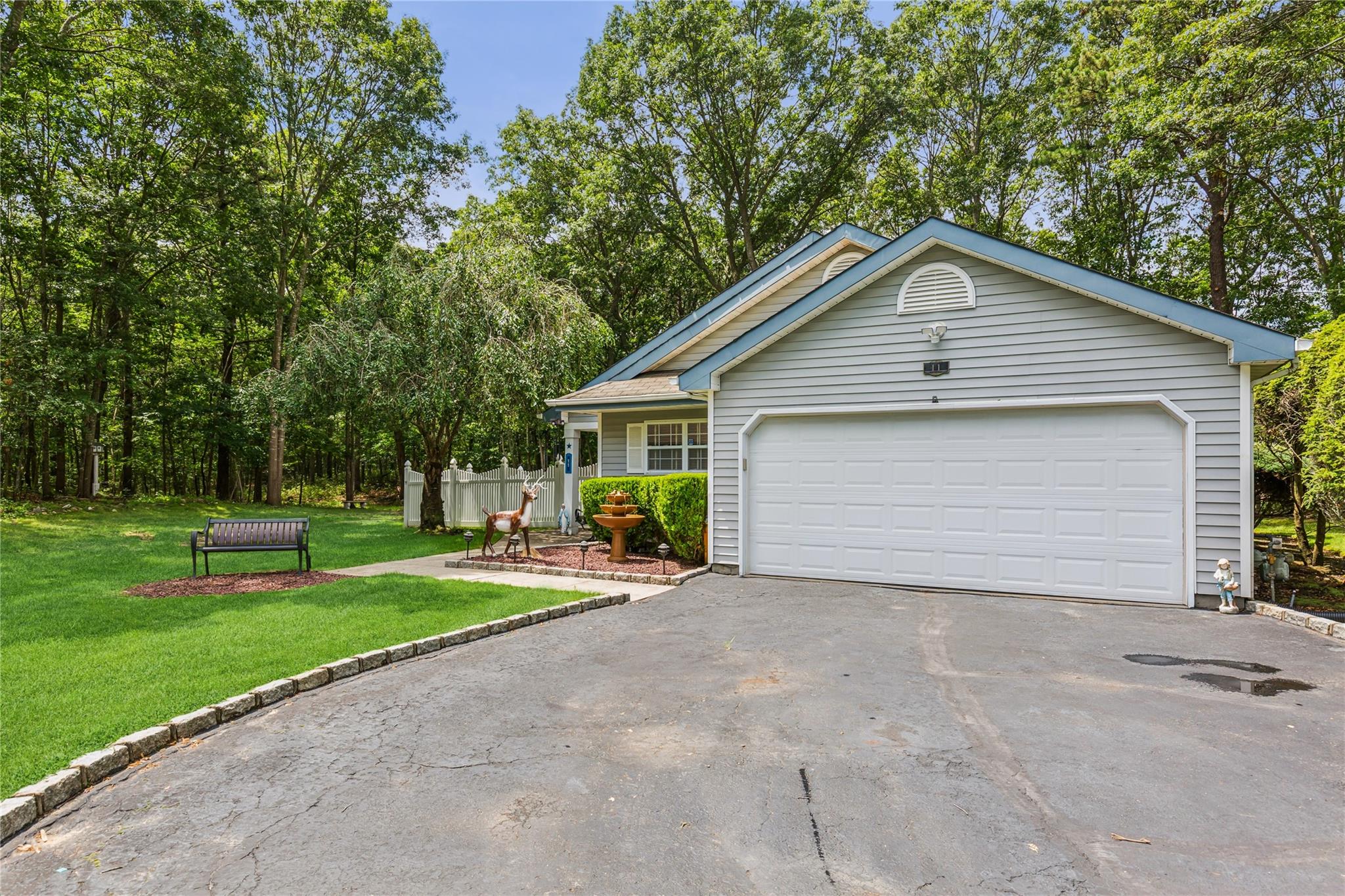 View of front of home with asphalt driveway and a front lawn