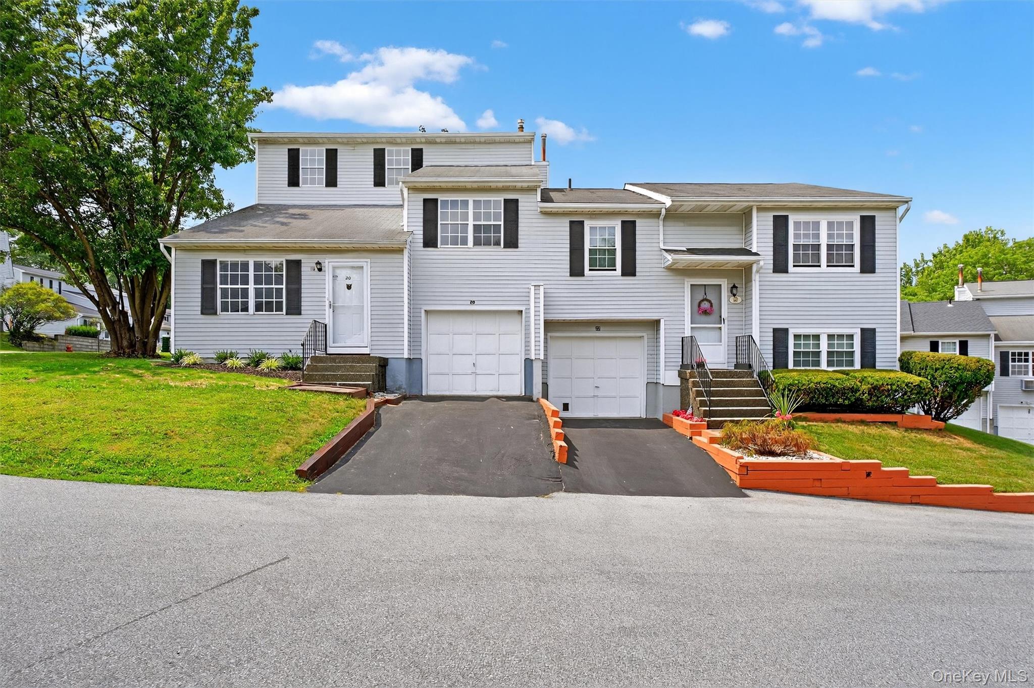 View of front of house with a garage, driveway, and a front yard