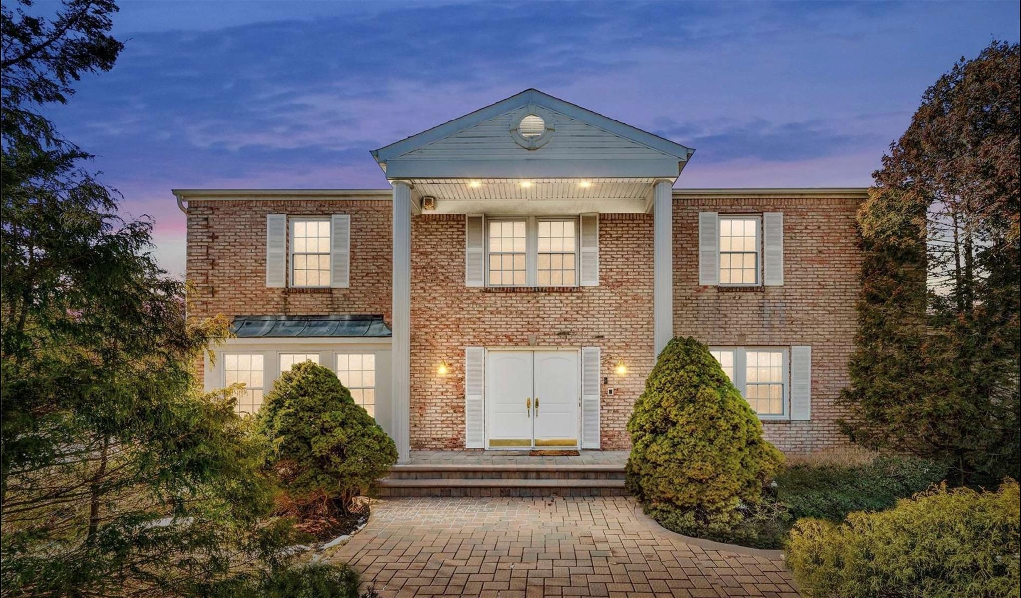 Colonial home featuring brick siding