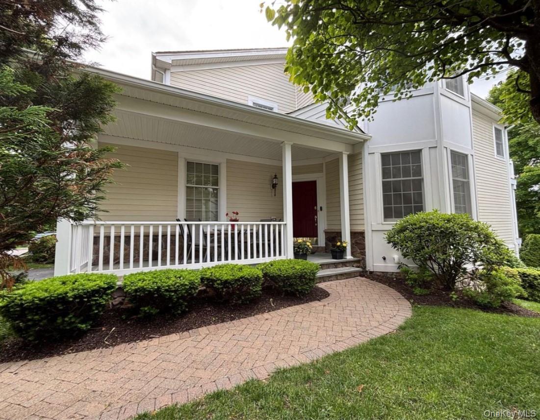 Entrance to property with covered porch and stone siding