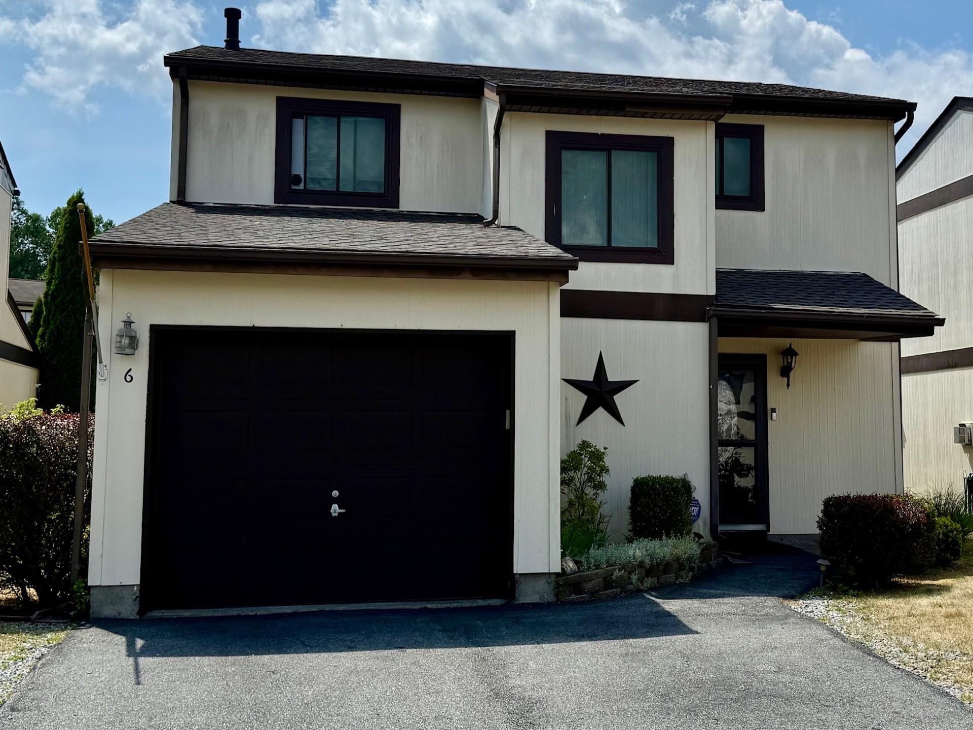 View of front of property with roof with shingles, driveway, and an attached garage