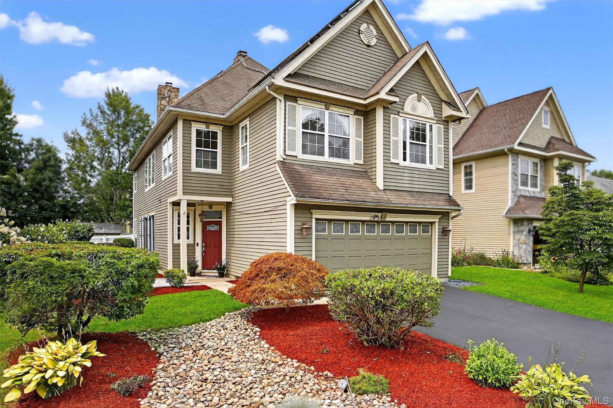 View of front of house with an attached two-car garage and welcoming curb appeal