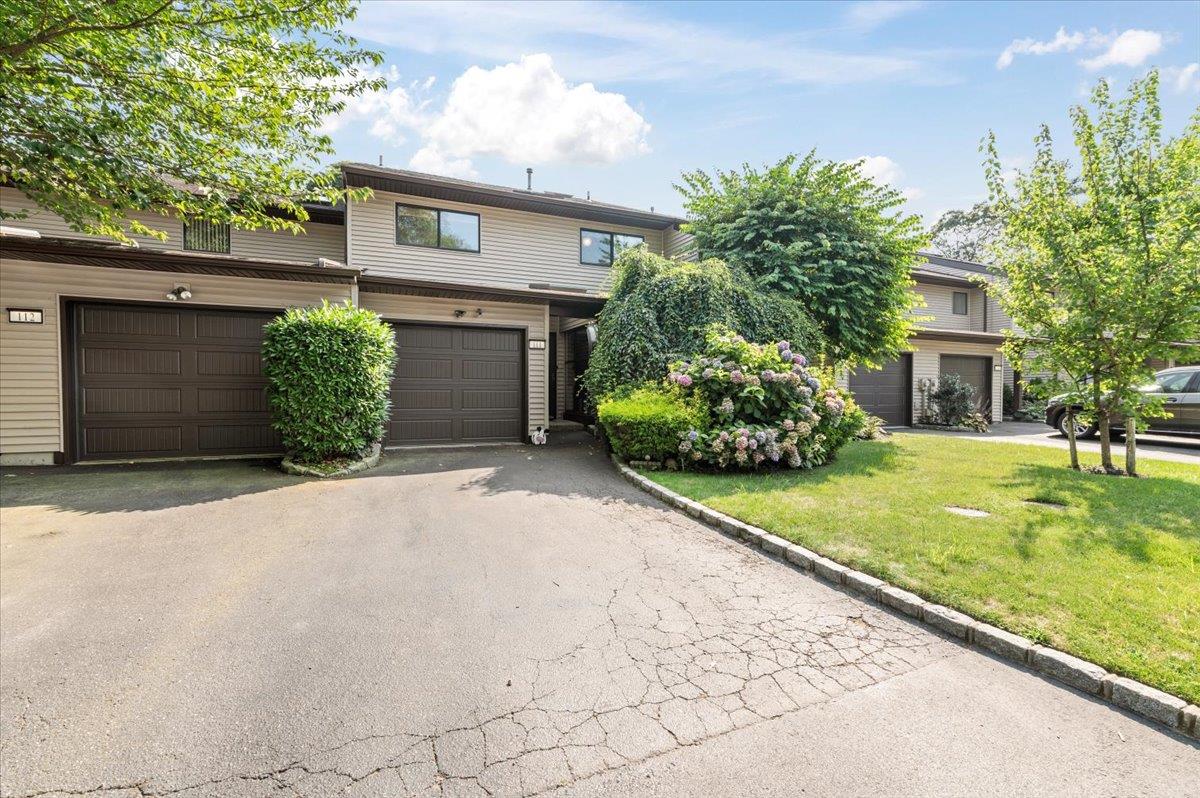 View of front of house featuring a front yard, driveway, and an attached garage