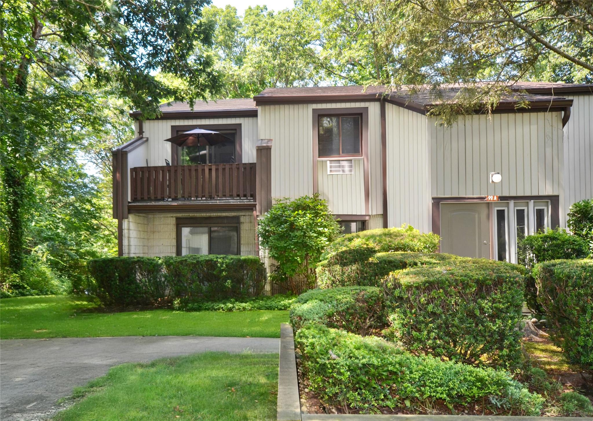 View of front of house with a front lawn and a balcony