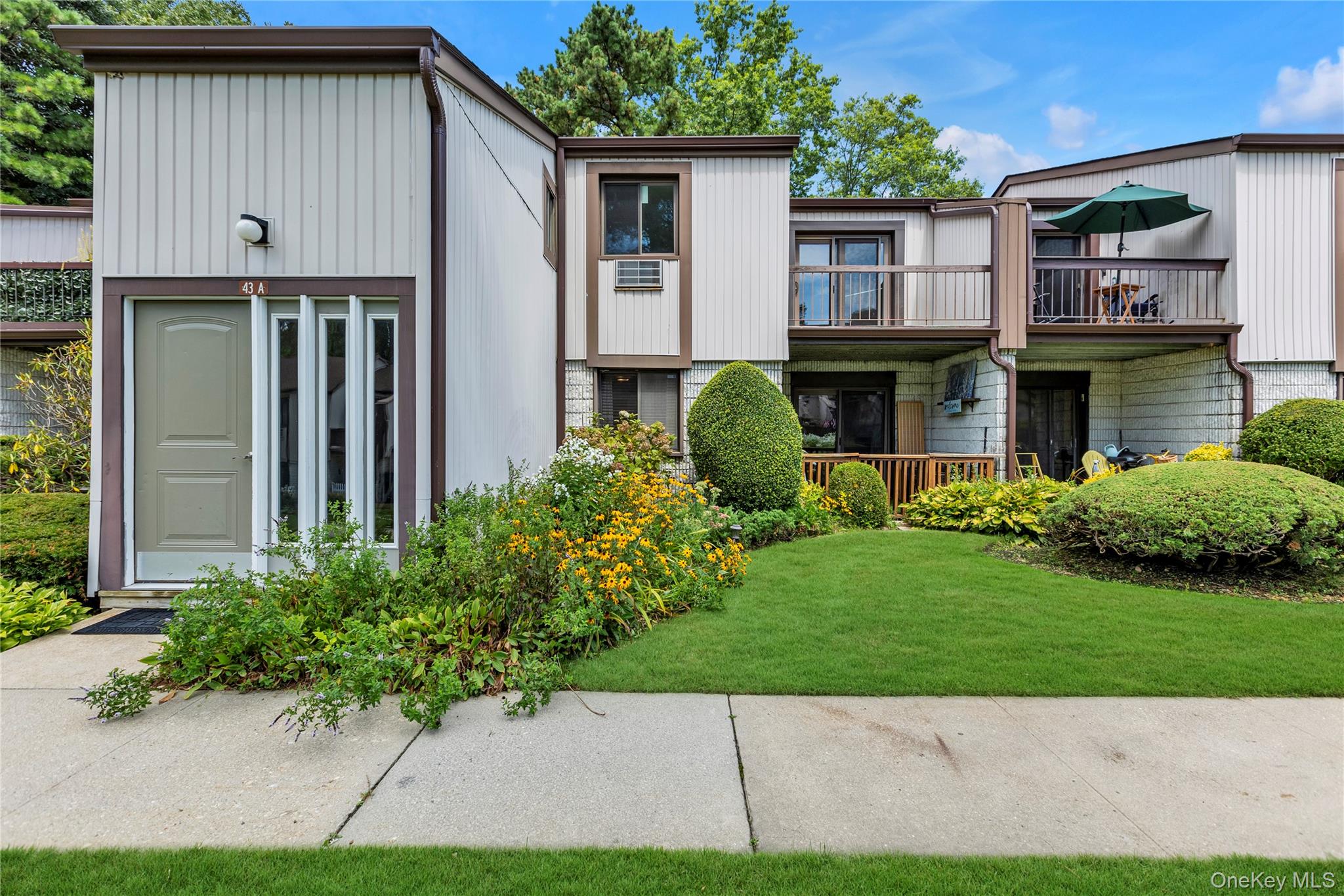 Mid-century home with a balcony and a front yard