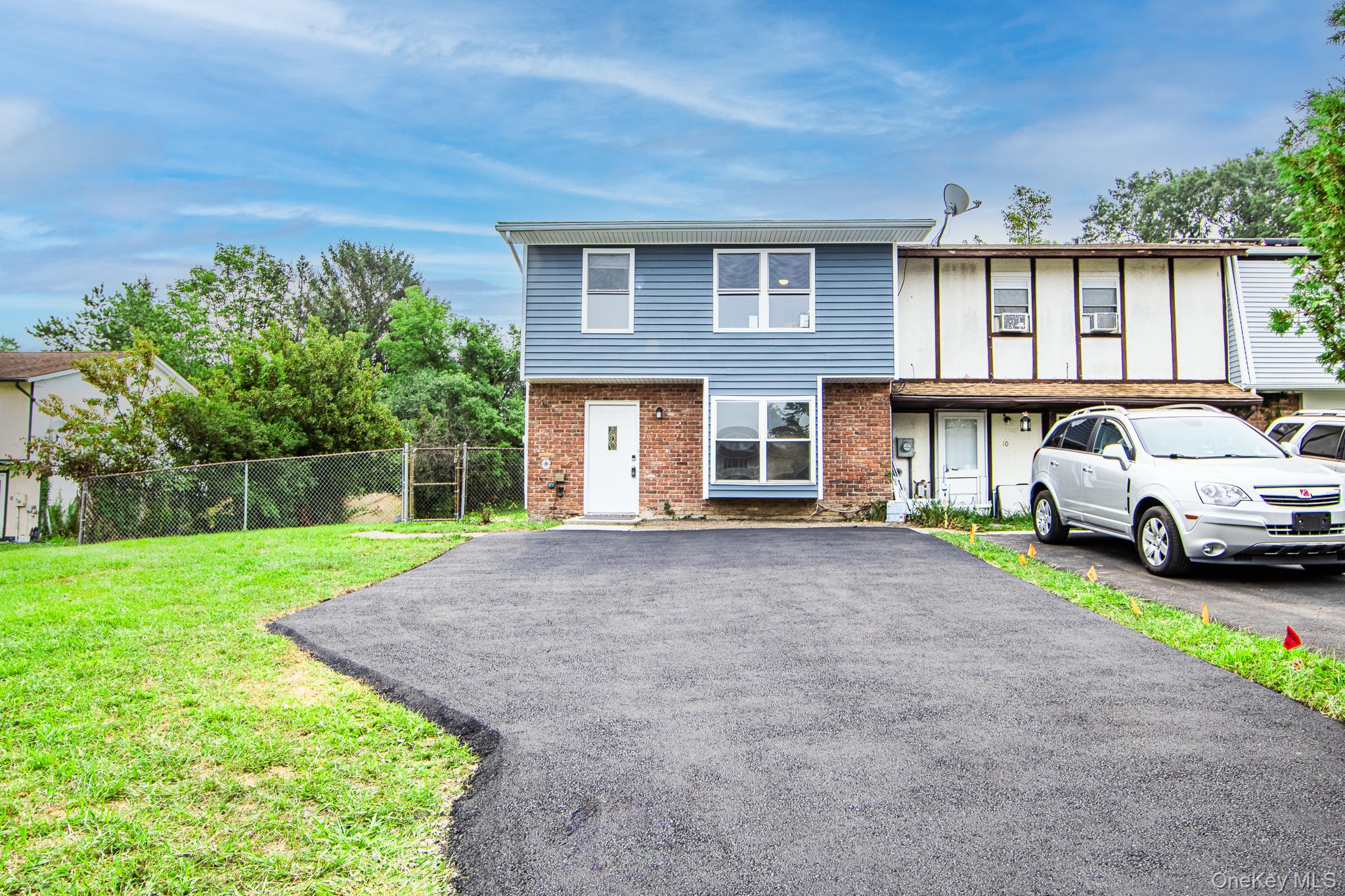 View of front facade featuring brick siding and asphalt driveway