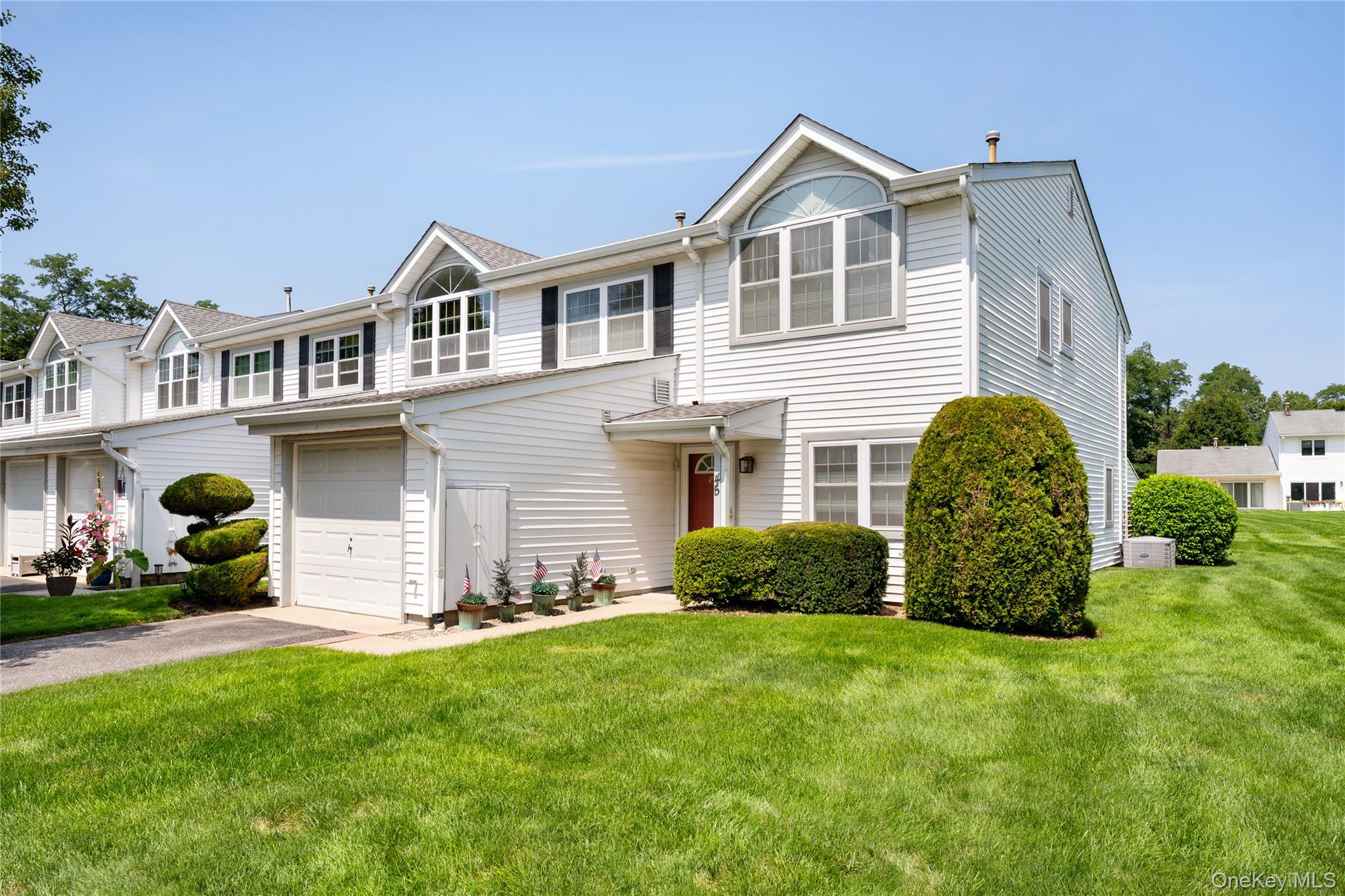 Traditional-style house featuring driveway, a garage, and a front yard