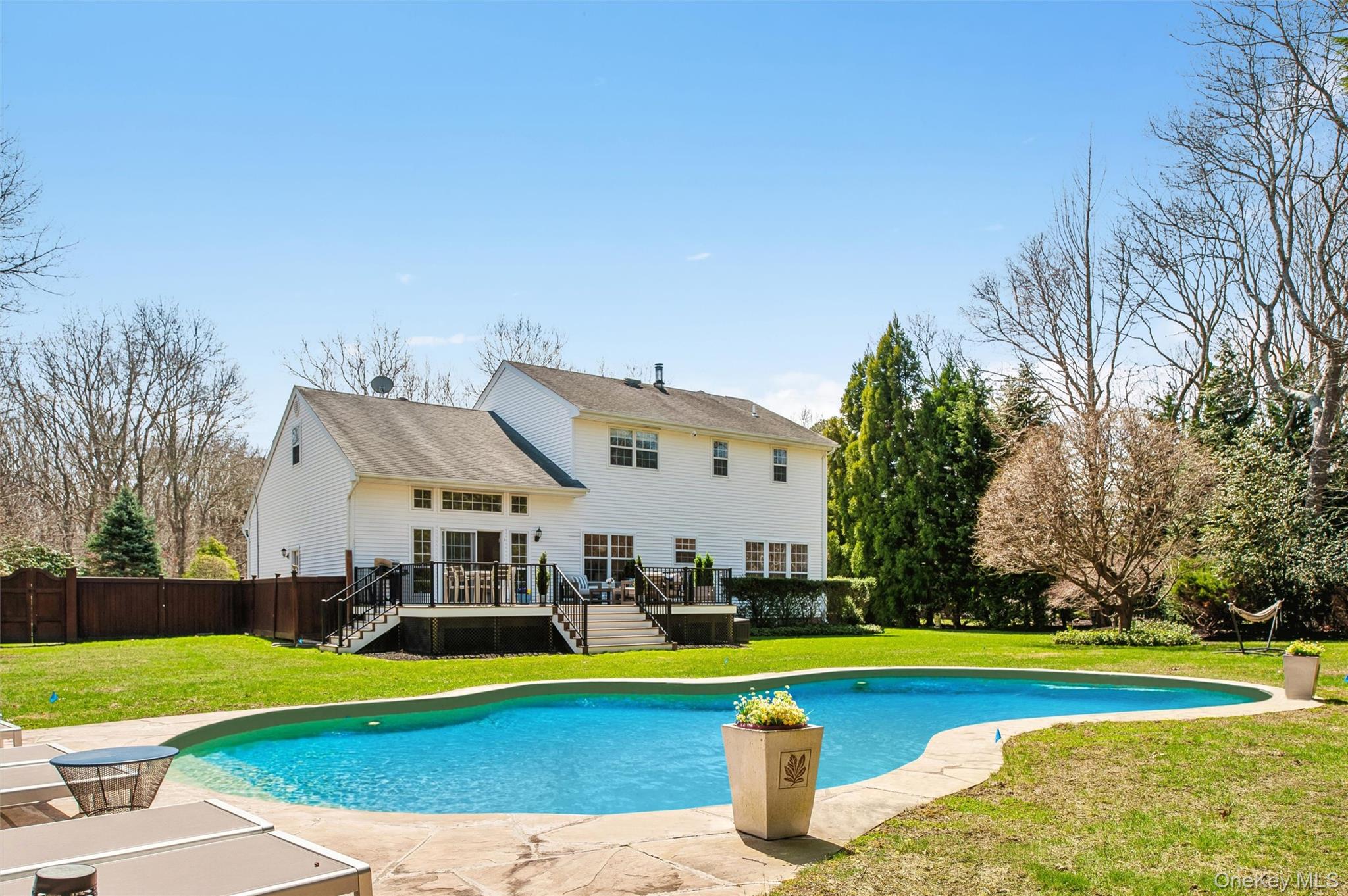 View of swimming pool featuring a lawn, stairs, a wooden deck, a fenced in pool, and fence private yard
