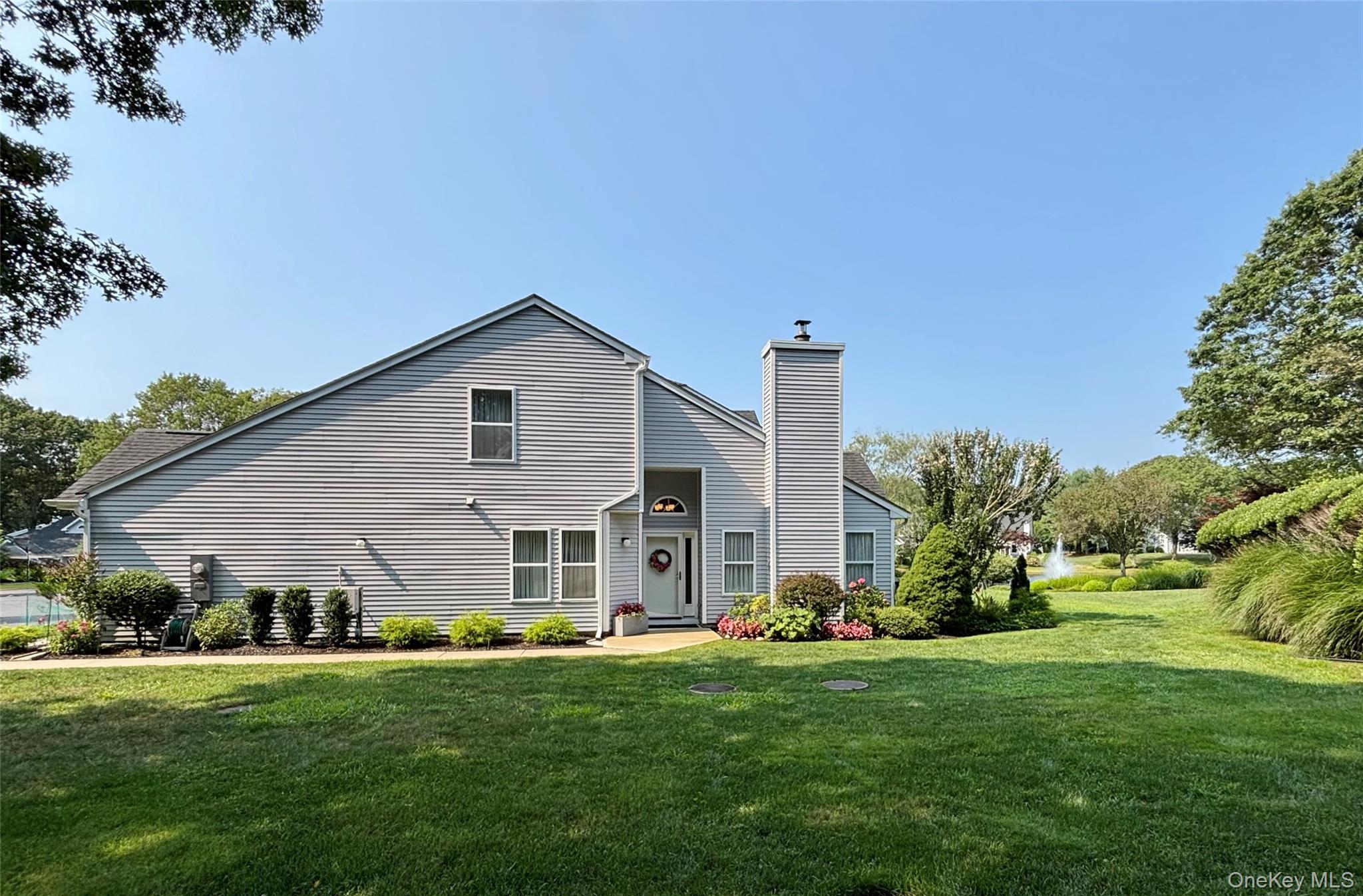 View of front facade with a chimney and a front lawn