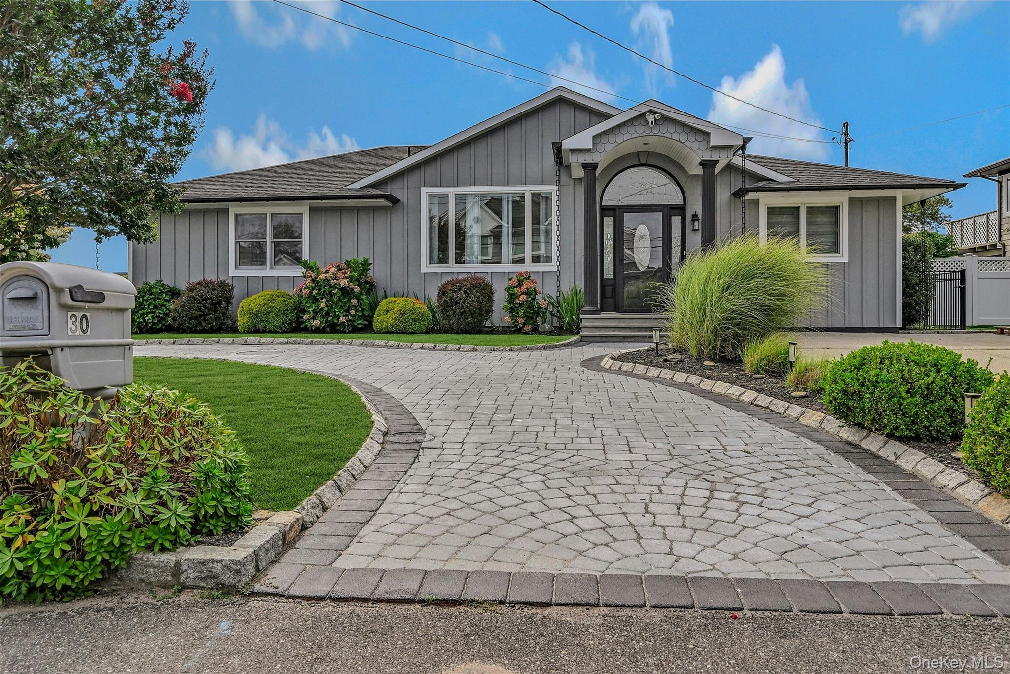 Single story home featuring a shingled roof, board and batten siding, and a front yard