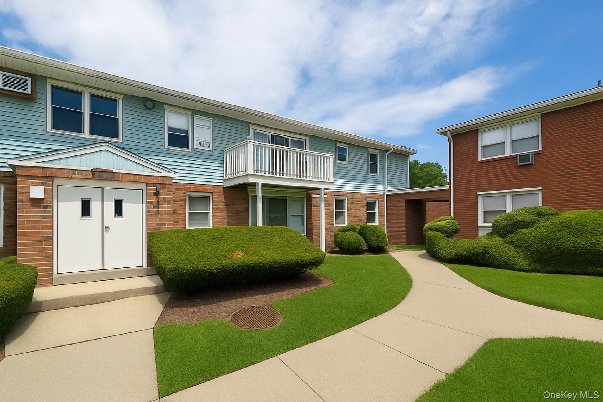 View of front of home with brick siding and a balcony
