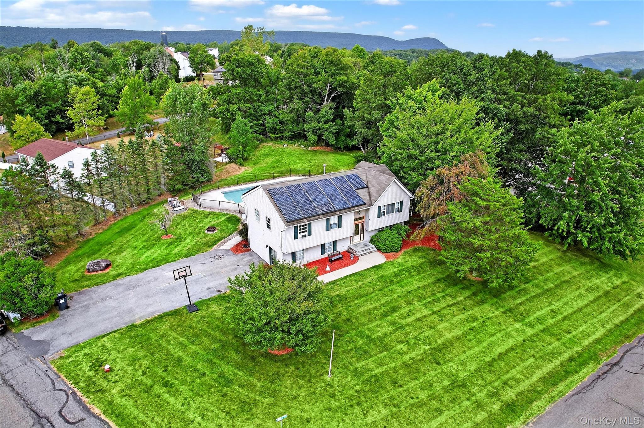 Aerial view of property and surrounding area featuring a mountain backdrop