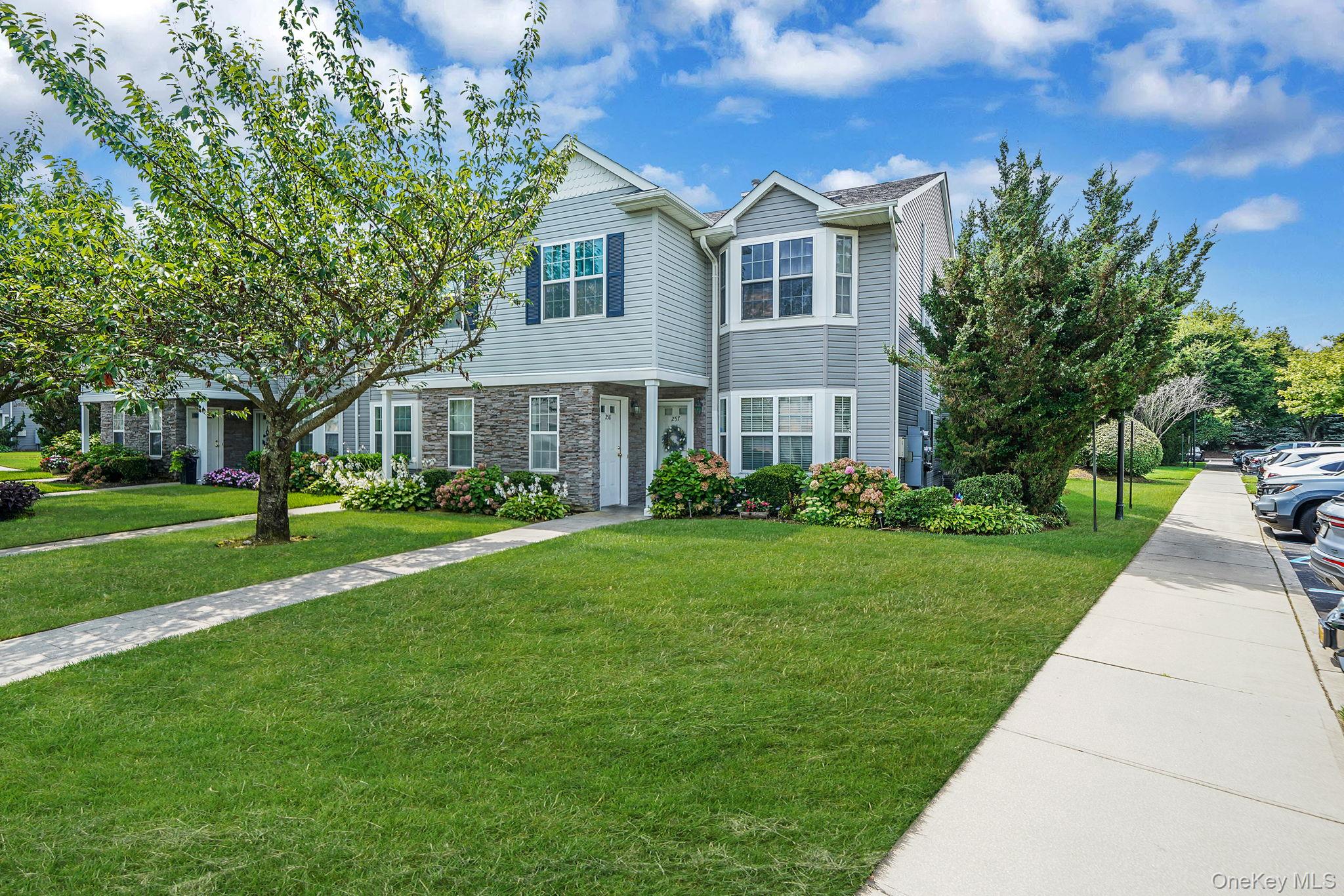 View of front of home with a front yard and stone siding