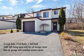 View of front of property featuring concrete driveway, stucco siding, and a garage