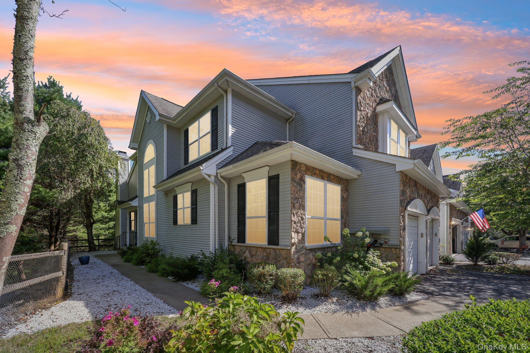 View of front of house with stone siding and a garage
