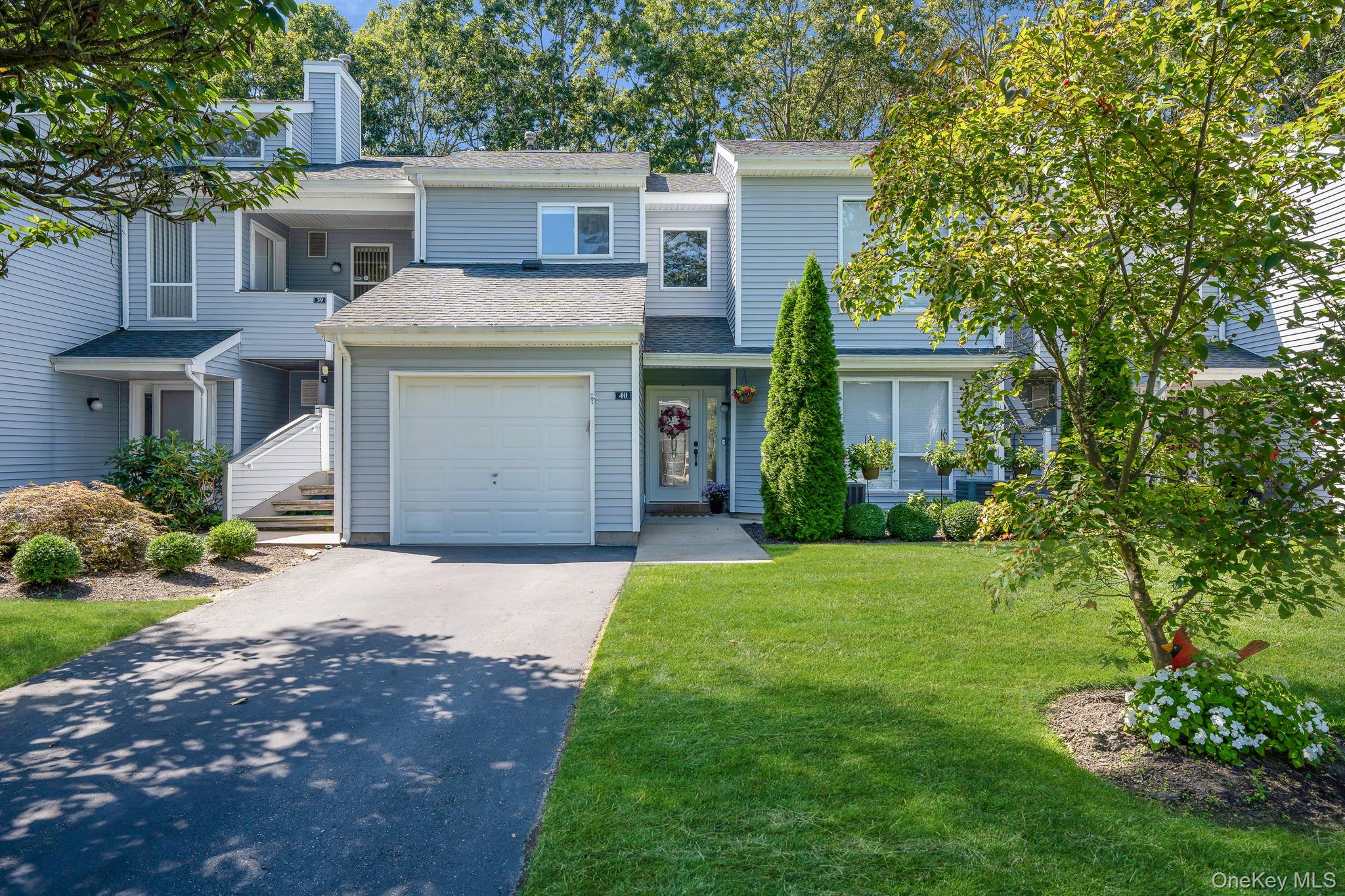 Traditional-style home with a shingled roof, asphalt driveway, a front yard, and a chimney