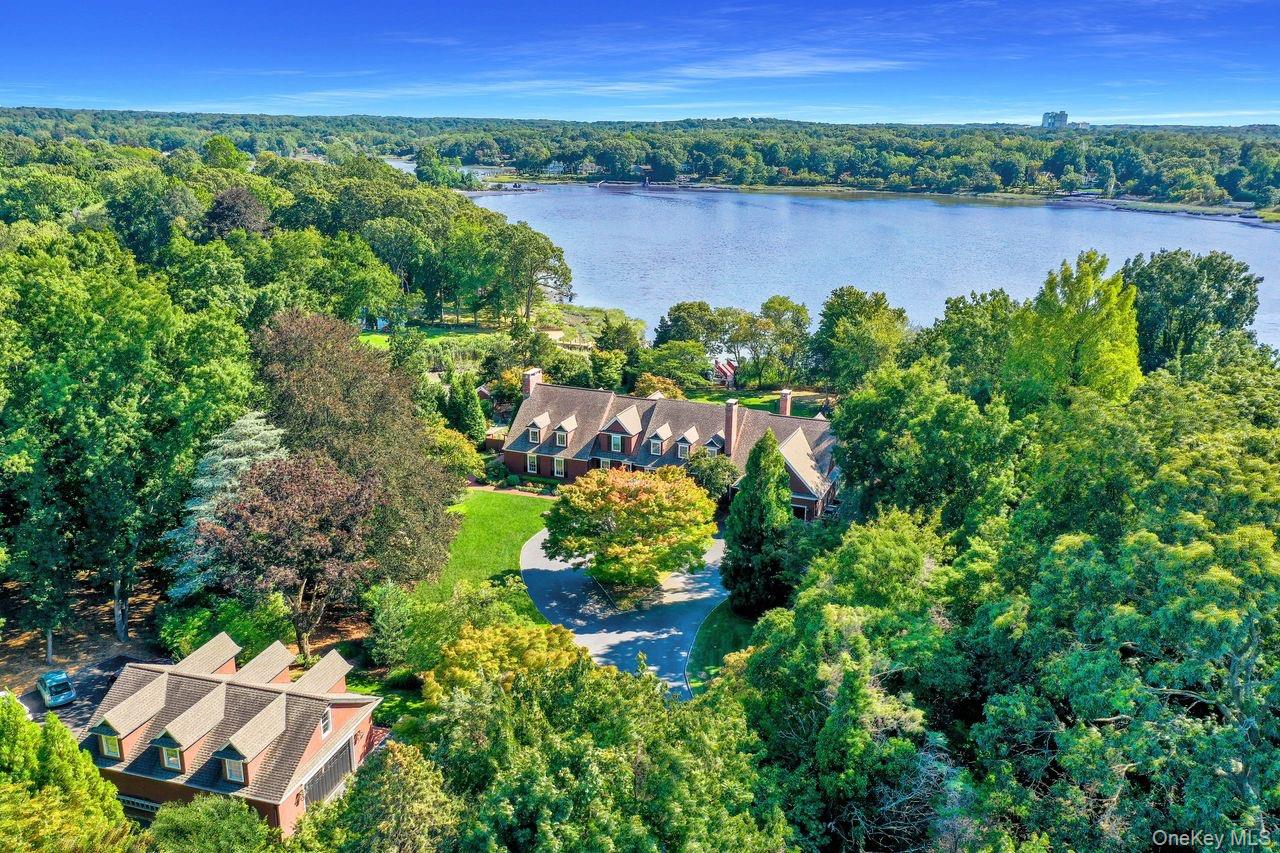 View of property location with a heavily wooded area and a nearby body of water