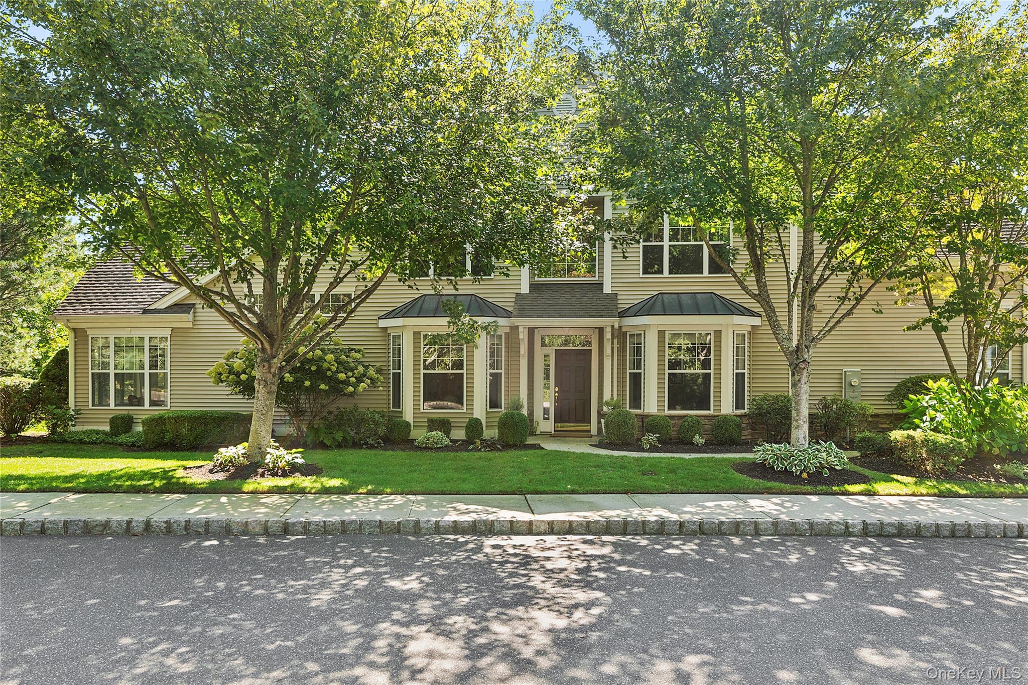 View of front of house with a standing seam roof, a front yard, and a metal roof