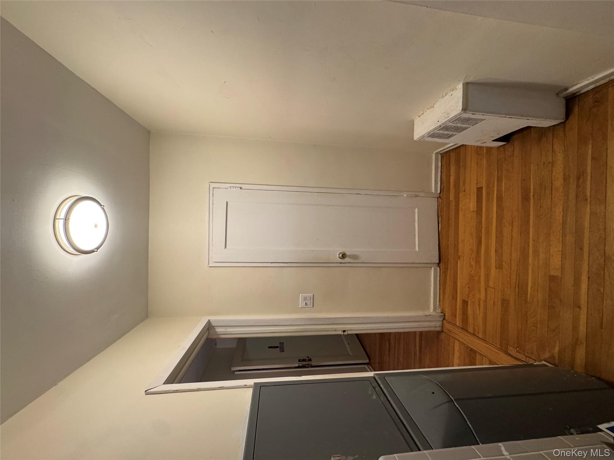 Hallway with light wood-style flooring and radiator heating unit