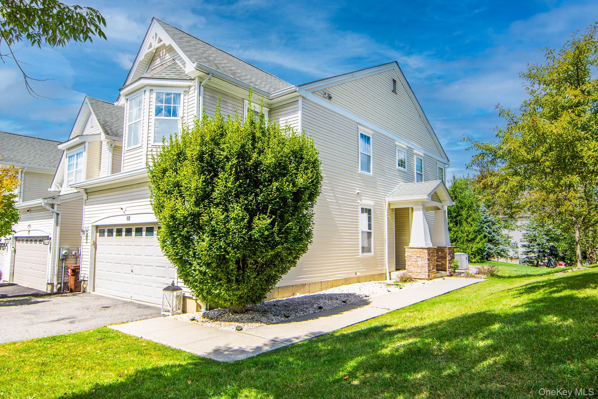 View of front of house featuring a front yard, asphalt driveway, an attached garage,