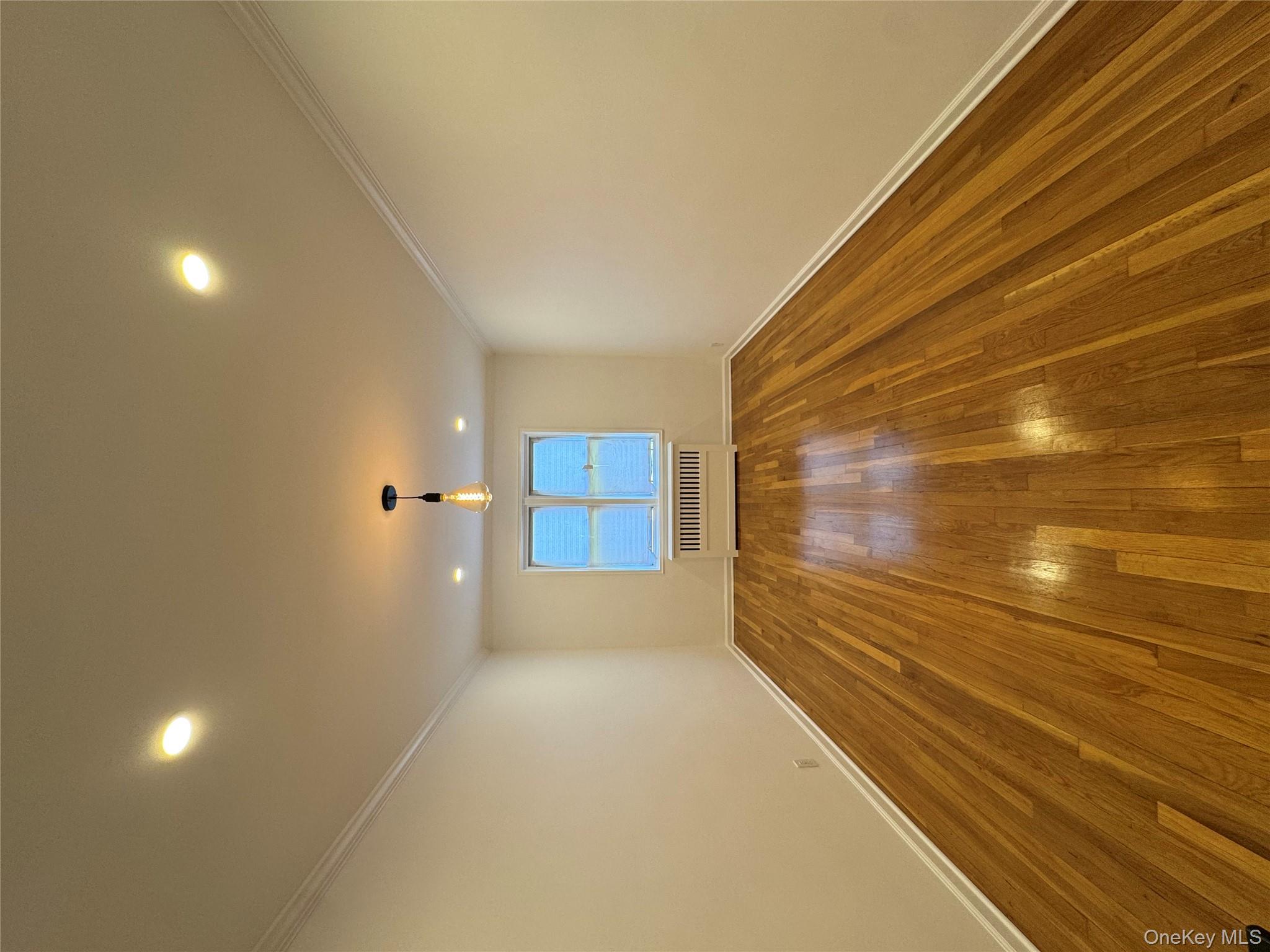 Spare room featuring ornamental molding, hardwood / wood-style floors, radiator, and recessed lighting