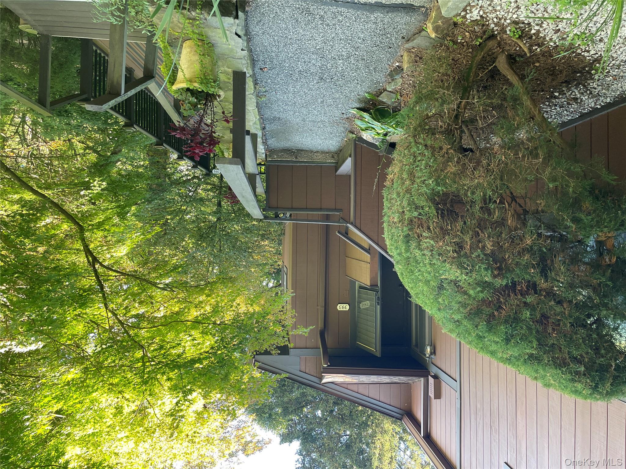 View of home's exterior featuring a balcony and view of wooded area