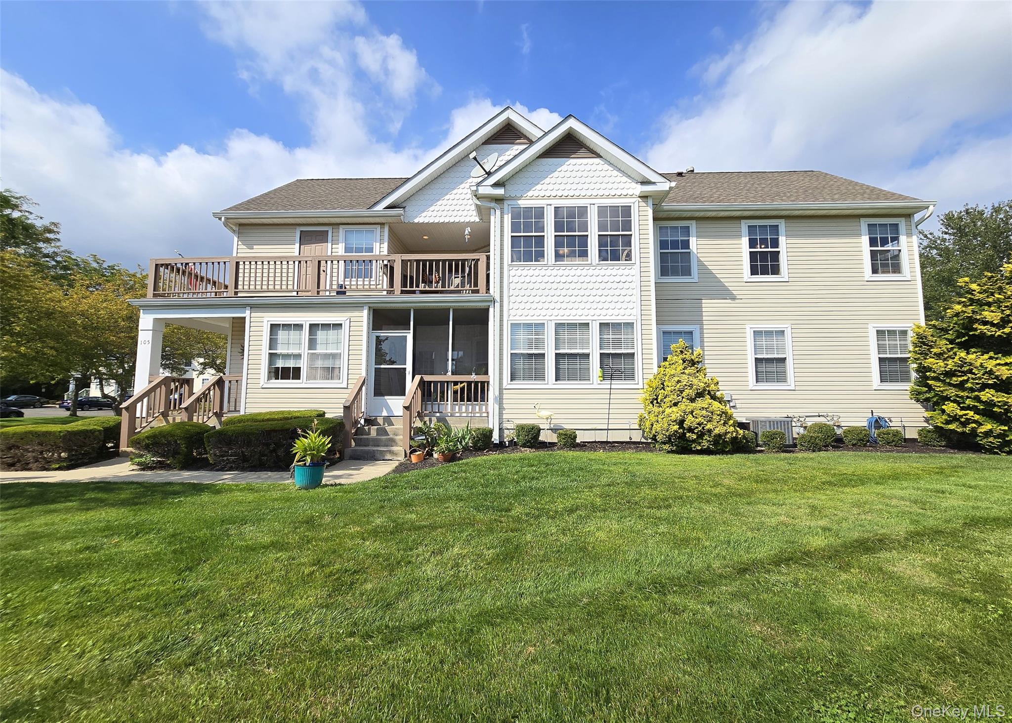 View of front facade featuring a wrap-around balcony, front lawn, a porch, and prime lake view.
