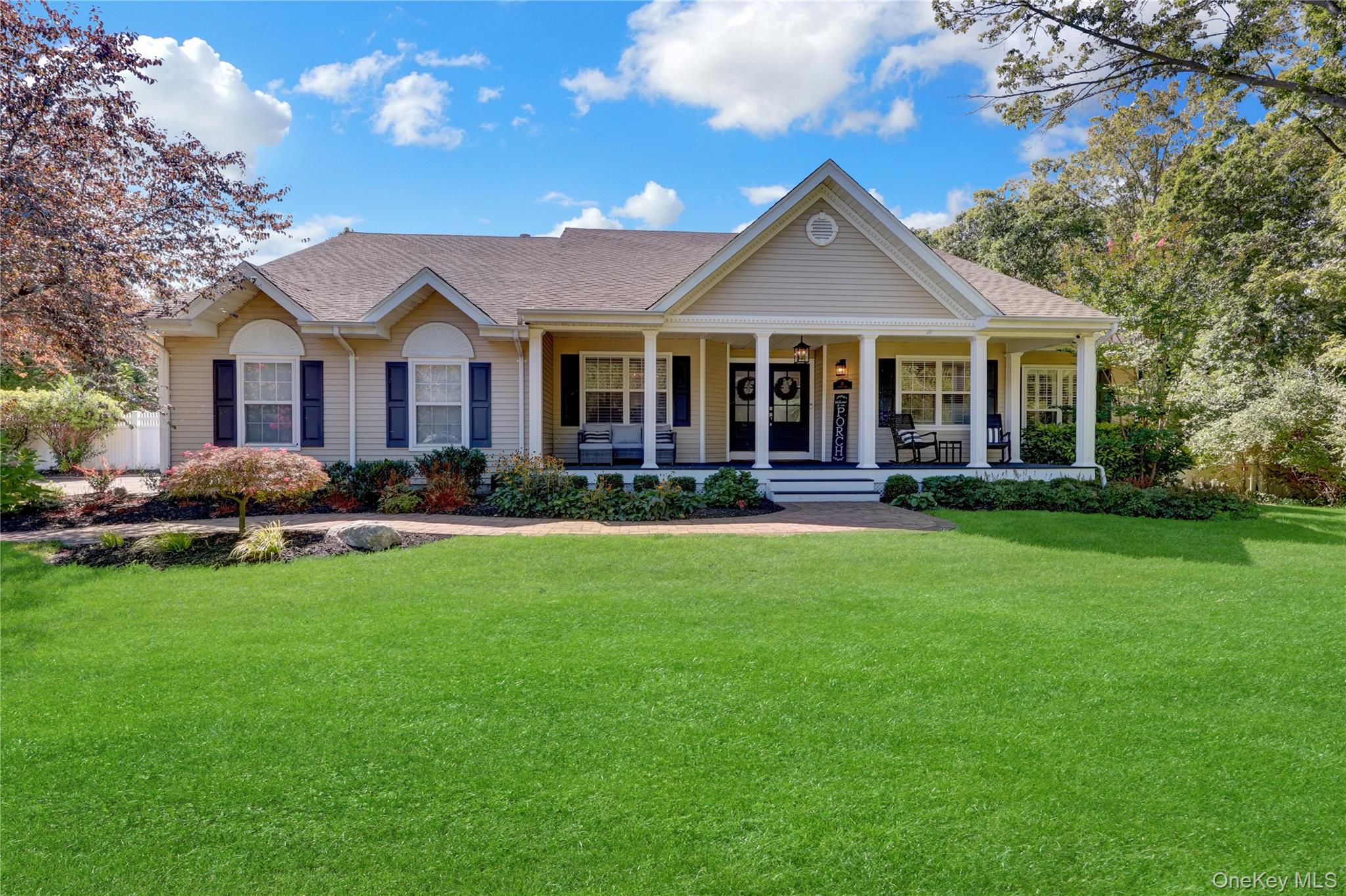 View of front of property featuring a porch, a shingled roof, and a front yard