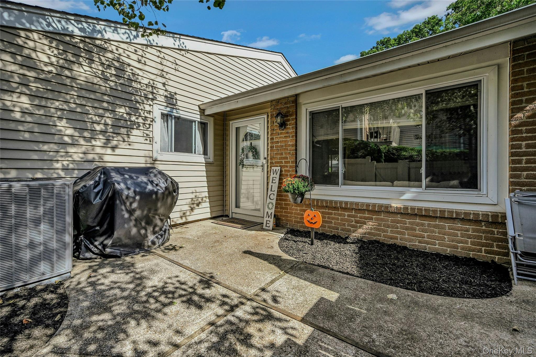 Doorway to property featuring a patio and brick siding