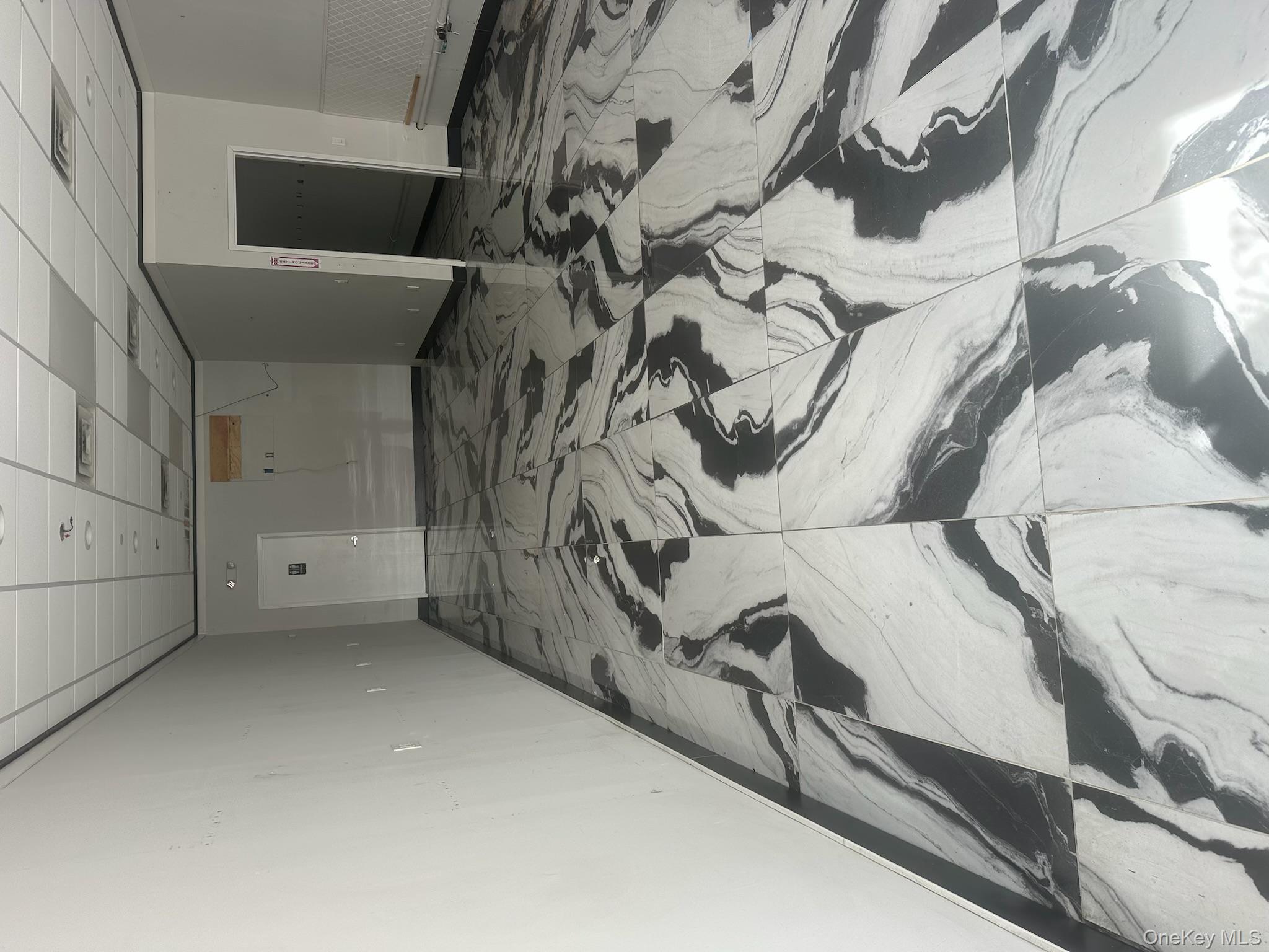 Unfurnished room featuring marble finish flooring and a paneled ceiling