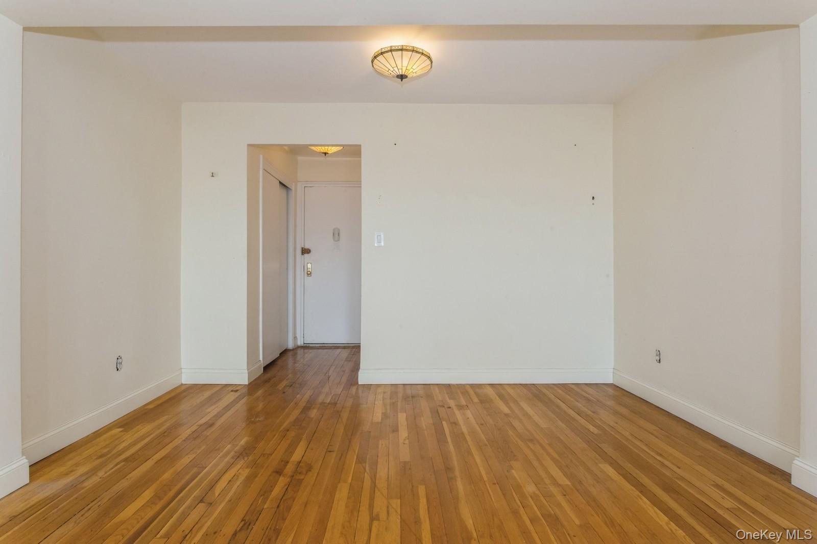 Spare room featuring light wood finished floors and baseboards