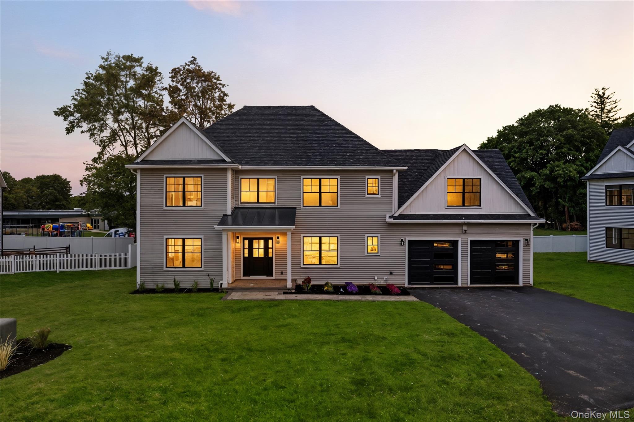 Modern farmhouse with asphalt driveway, a garage, and roof with shingles