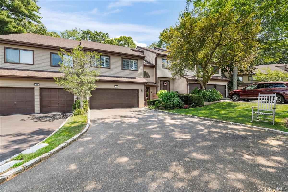 driveway, roof with shingles, and an attached garage
