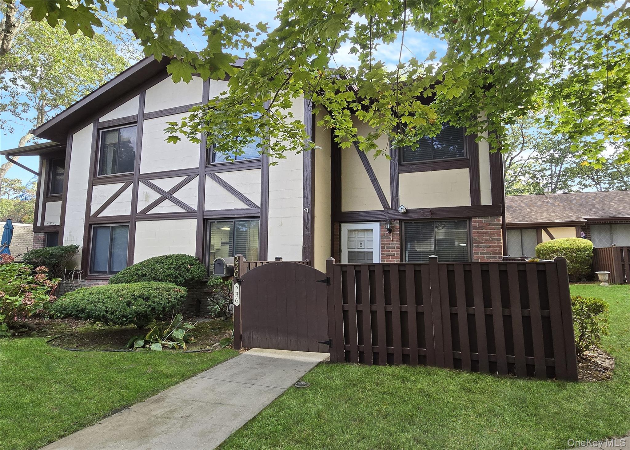 Tudor home featuring brick siding, a gate, and a fenced front yard