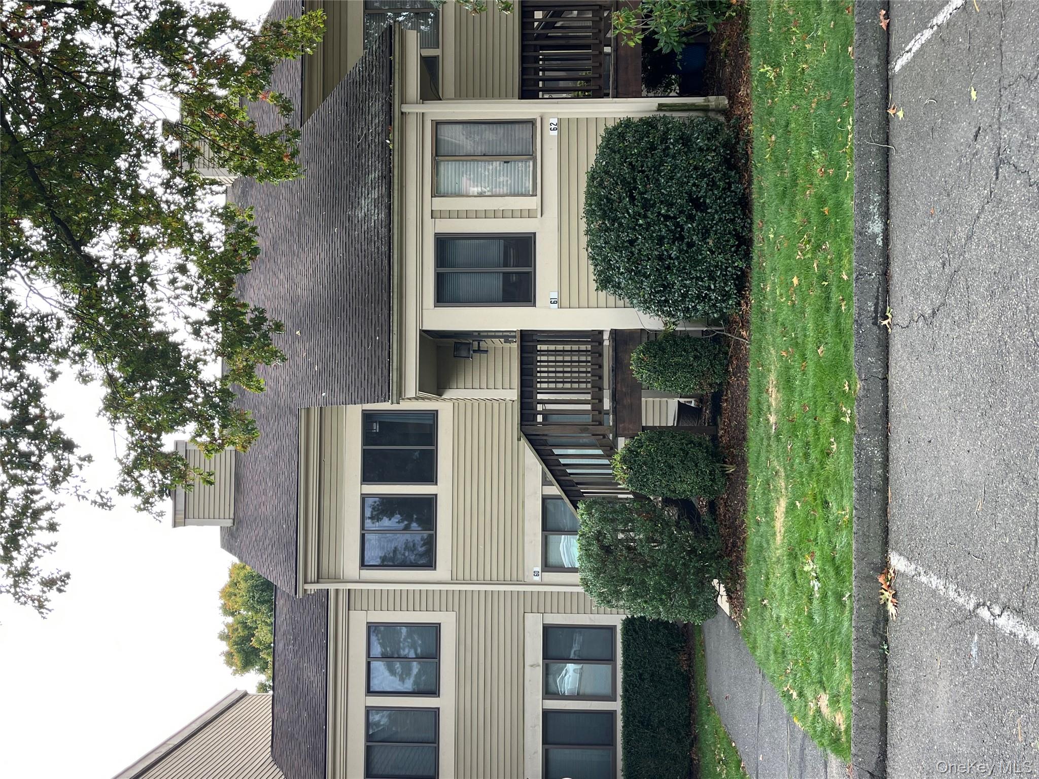 View of front of house featuring a front yard and a shingled roof