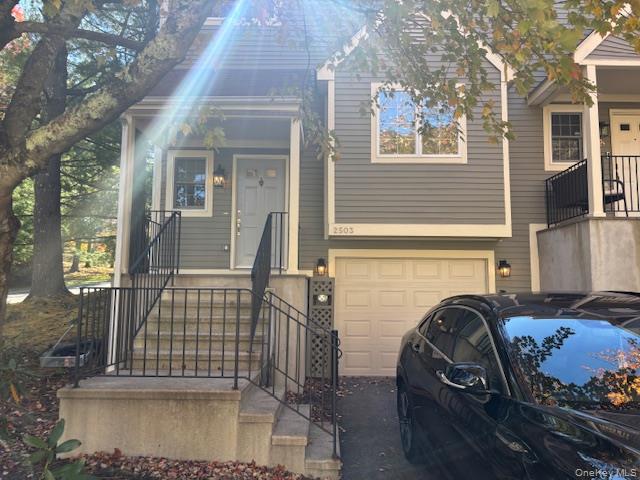 View of front of property featuring an attached garage and driveway