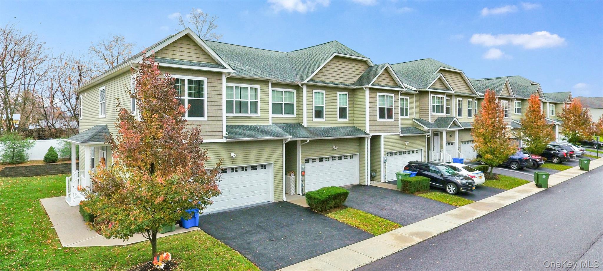 View of front of home featuring roof with shingles, driveway, a garage, and a residential view