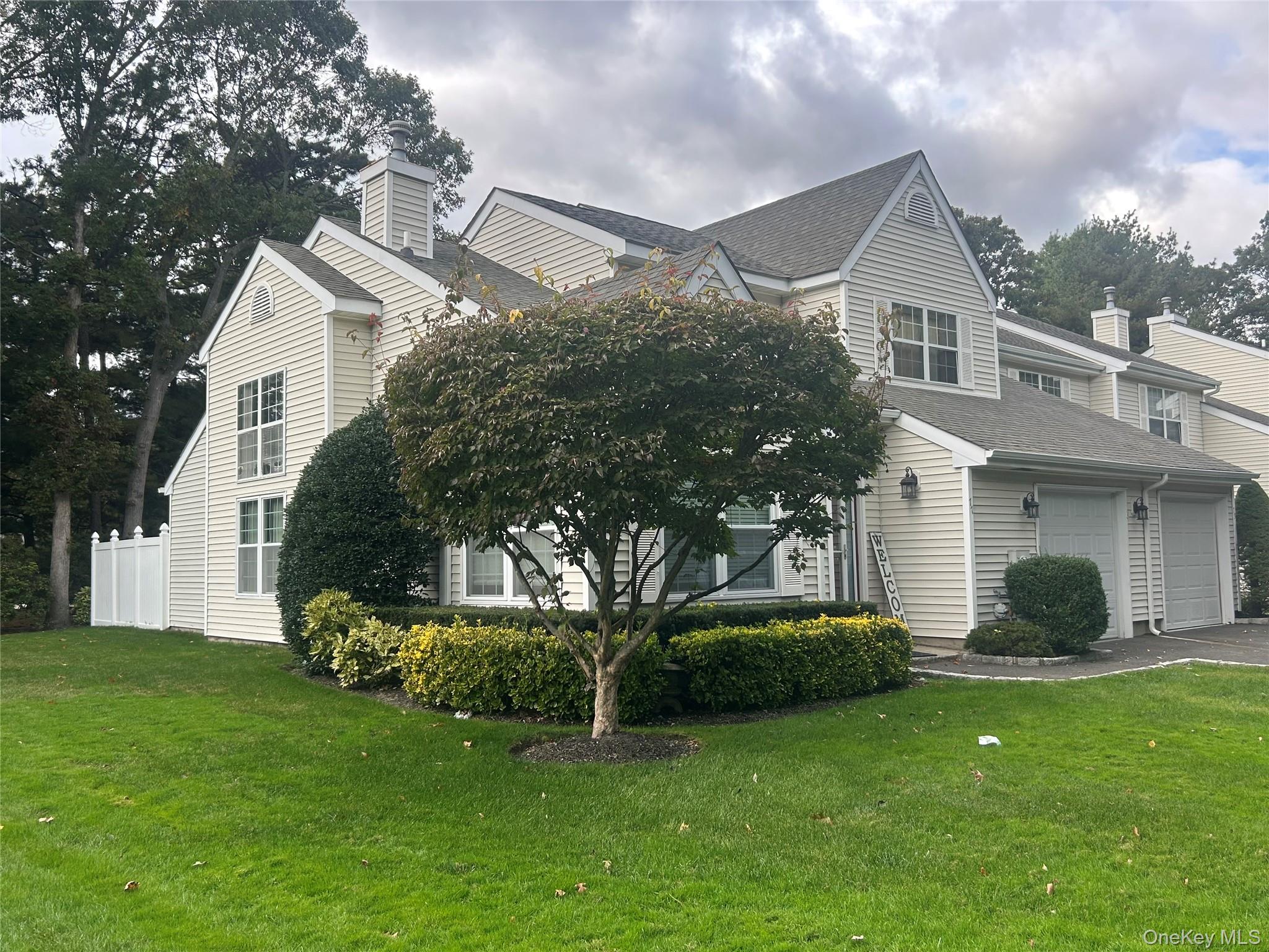 View of side of property featuring roof with shingles and asphalt driveway