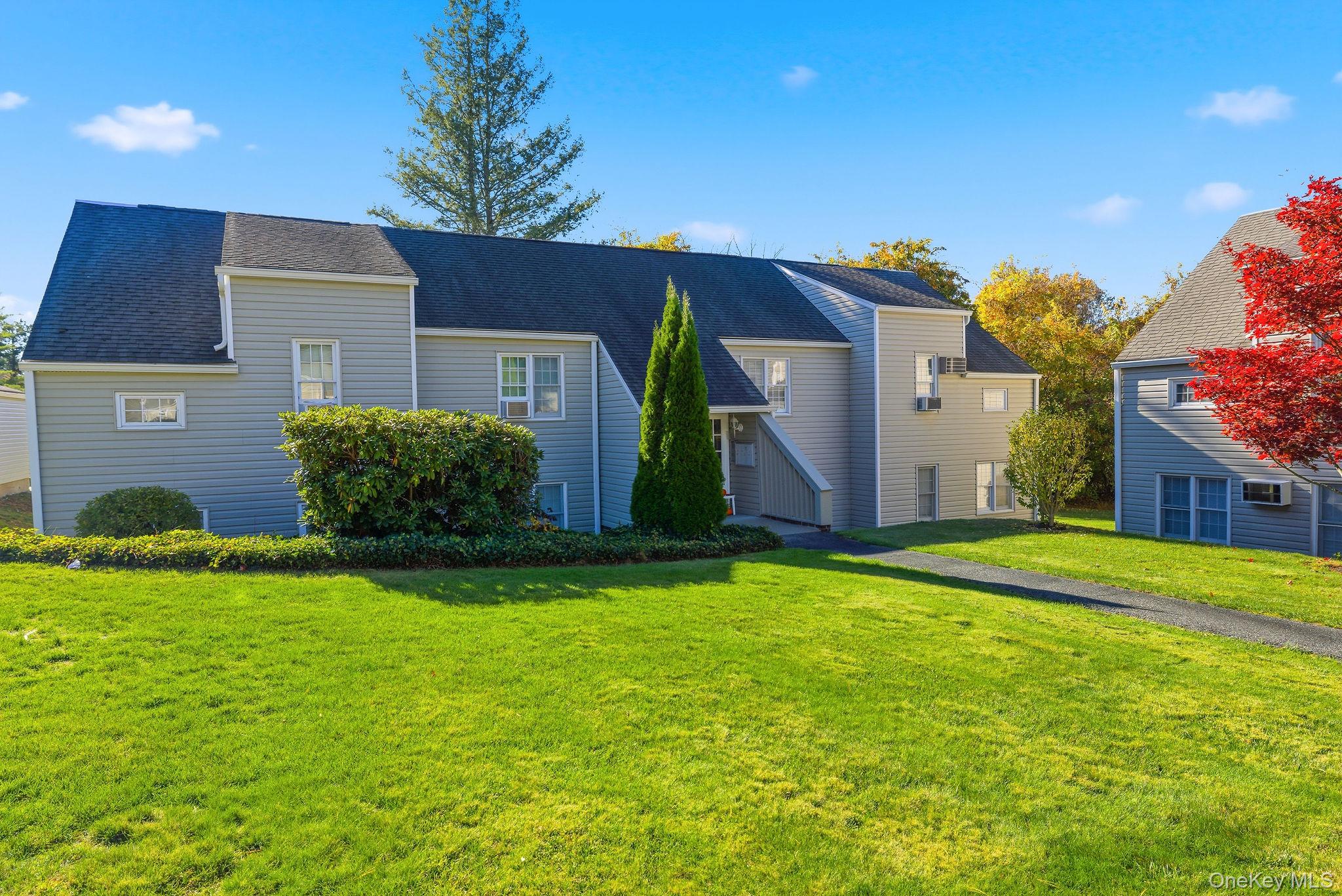 View of front of property featuring a front yard and a shingled roof