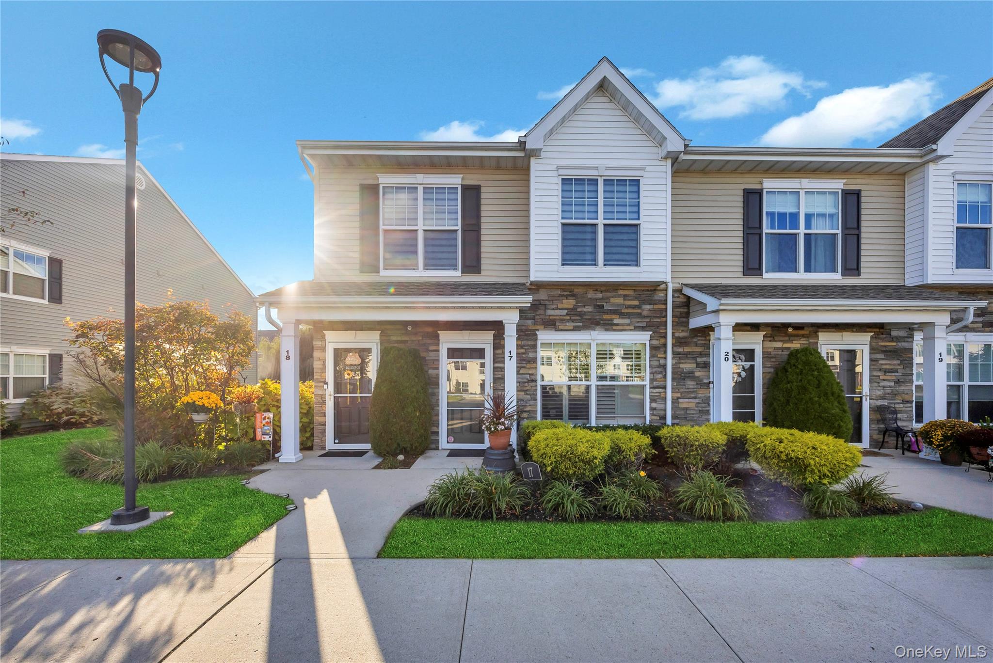 View of front of home with stone siding and a front lawn