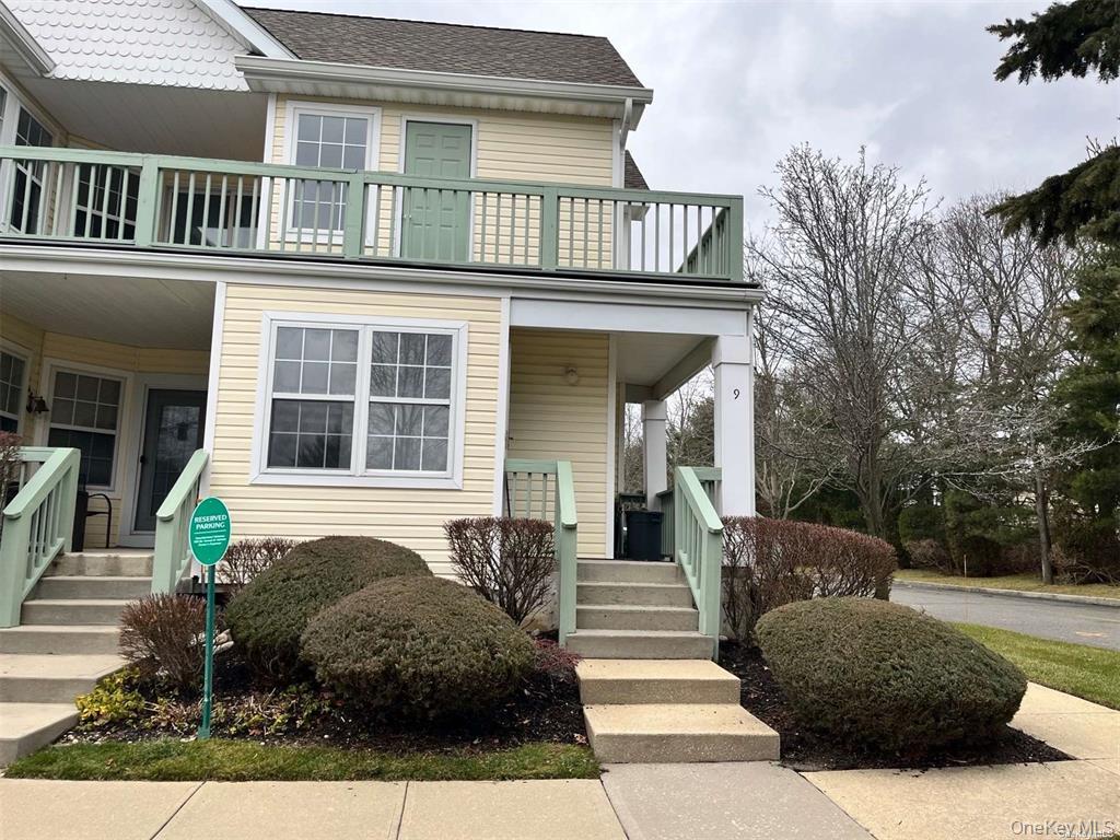 View of front of property featuring a shingled roof, a balcony, and covered porch
