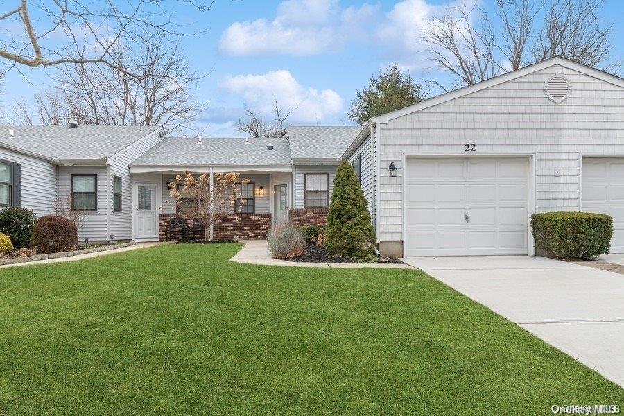Ranch-style home featuring a front lawn, concrete driveway, and a garage