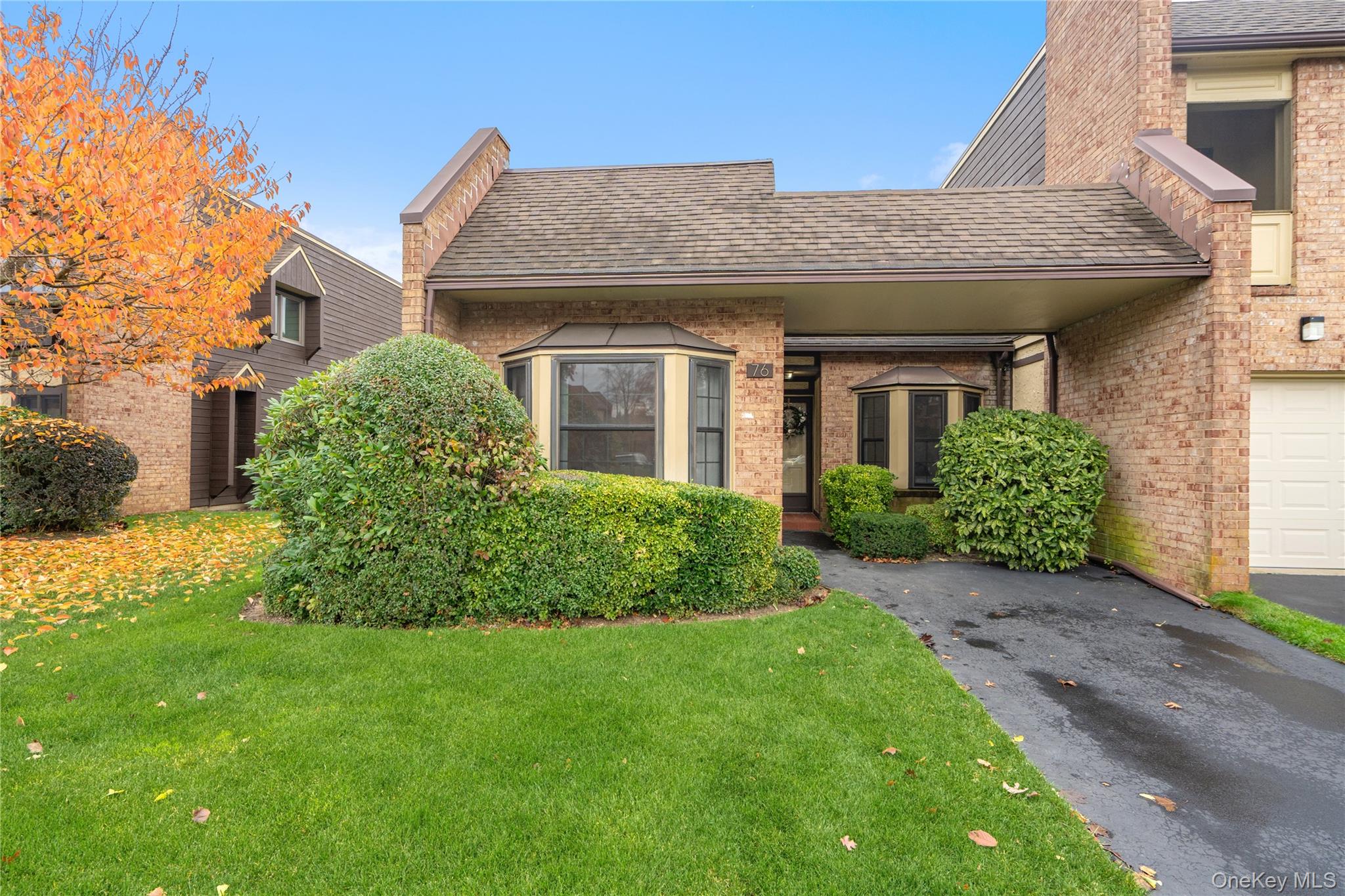View of front of home with brick siding, a front lawn, and a shingled roof