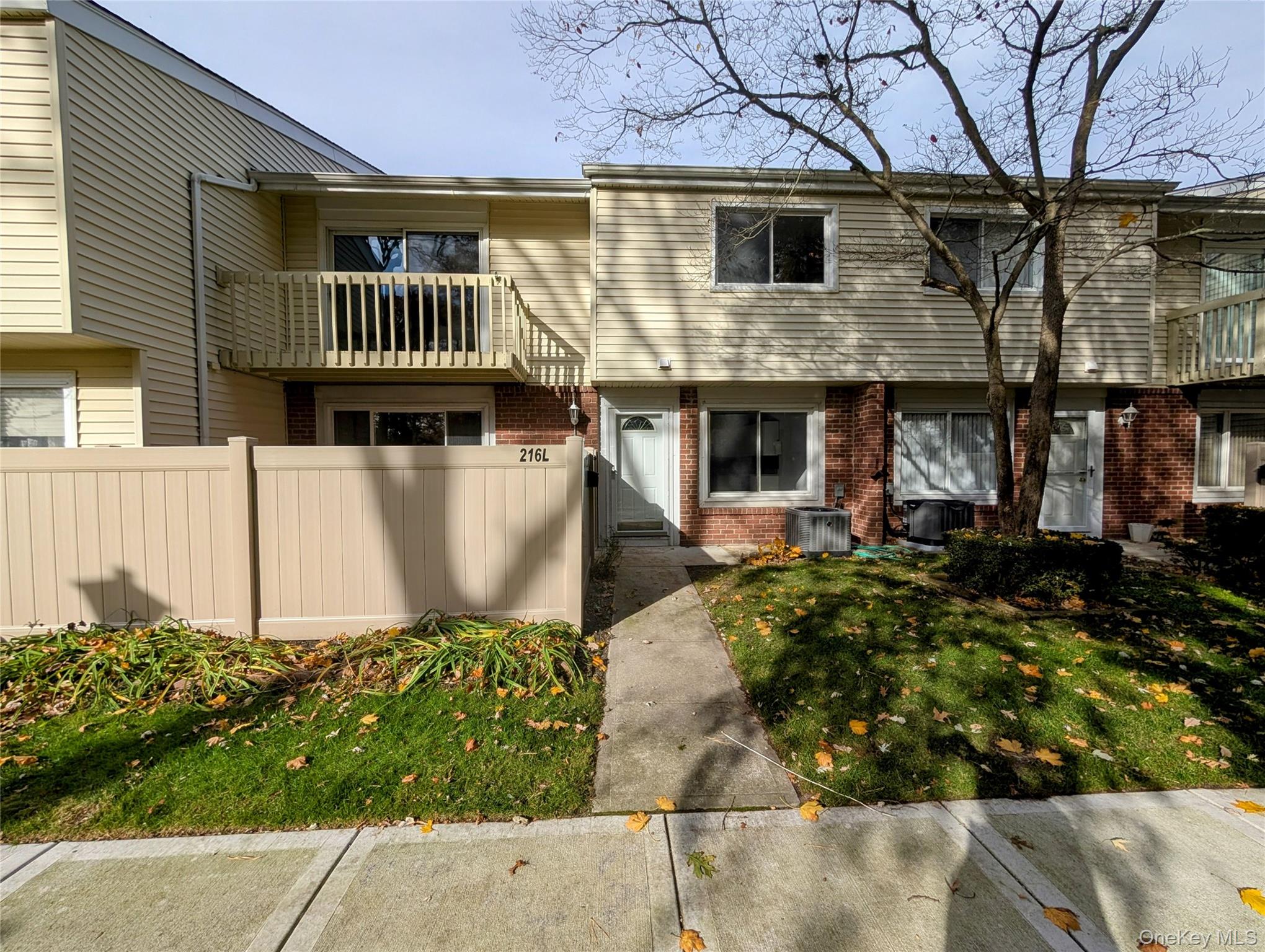 View of front of home with brick siding and a balcony